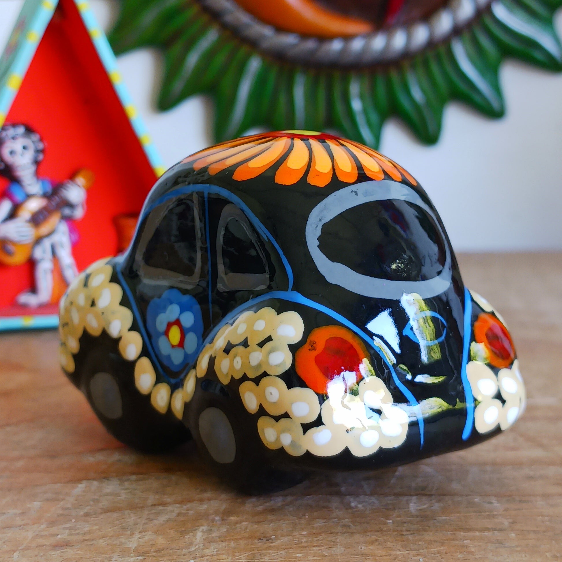 This fun little VW car ornament oozes retro vibes.  With it's bold flower power design and vibrant colours it will brighten up any sideboard.  This type of car, affectionately known as a 'bochito', are very popular in Mexico due to their reliability when driving about steep roads. Incidentally, the Mexican town of Puebla was home to the last Beetle production factory which only closed in 2003.