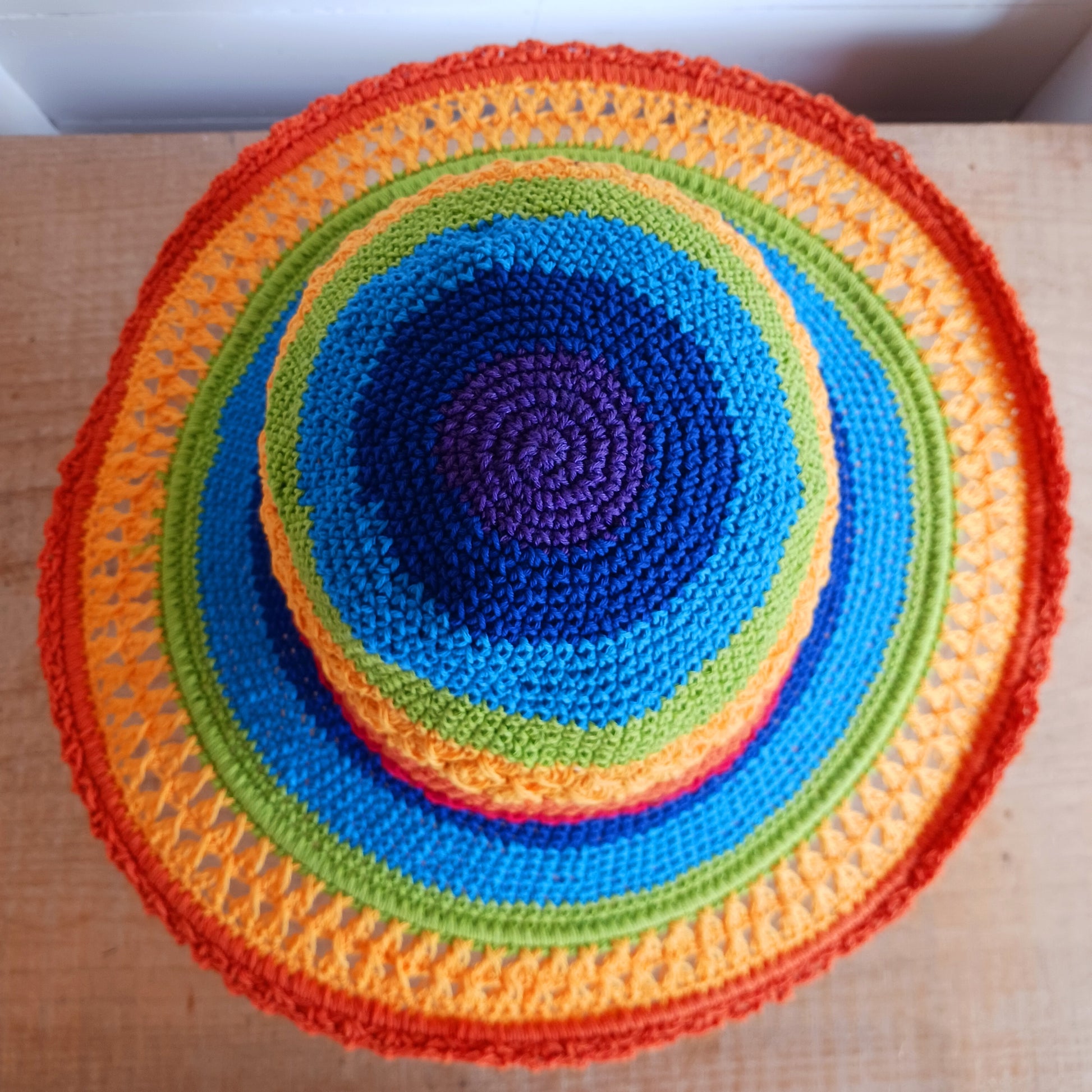Brighten up your summer with this vibrant handmade crochet cotton sun hat! Featuring a stunning rainbow pattern, this unique hat is perfect for holidays, beach days, and festivals. A malleable wire is carefully woven into the rim, allowing you to shape the brim just how you like it. Lightweight and breathable, it's ideal for sunny adventures. Each hat is individually handcrafted, so you’ll receive the exact one pictured – a one-of-a-kind accessory to celebrate the season in style.