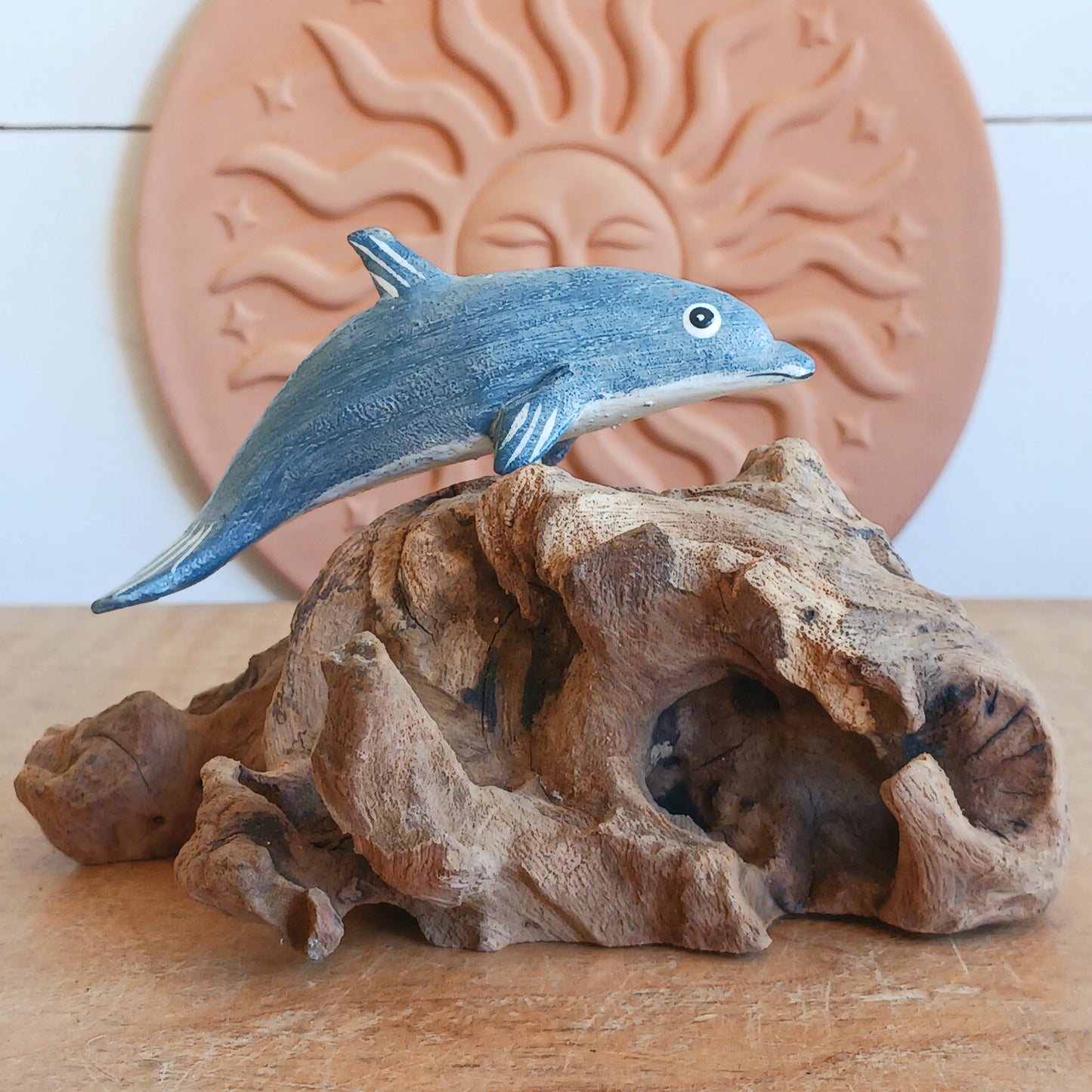 Bring the peaceful beauty of the ocean into your home with this Handcrafted Wooden Blue Dolphin Sculpture. Expertly crafted from sustainably sourced wood, this elegant decorative piece features a beautifully hand-painted blue dolphin gracefully mounted on natural driftwood, creating a striking coastal-inspired display.