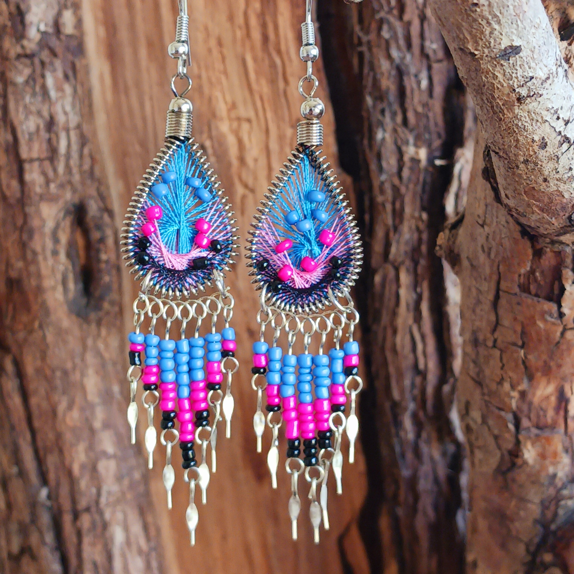 Add a splash of colour to your look with these beautiful handmade Peruvian woven teardrop earrings. Inspired by the vibrant colours and patterns of a peacock feather, each earring features intricate woven detailing complemented by coordinating beads and delicate silver-tone embellishments.