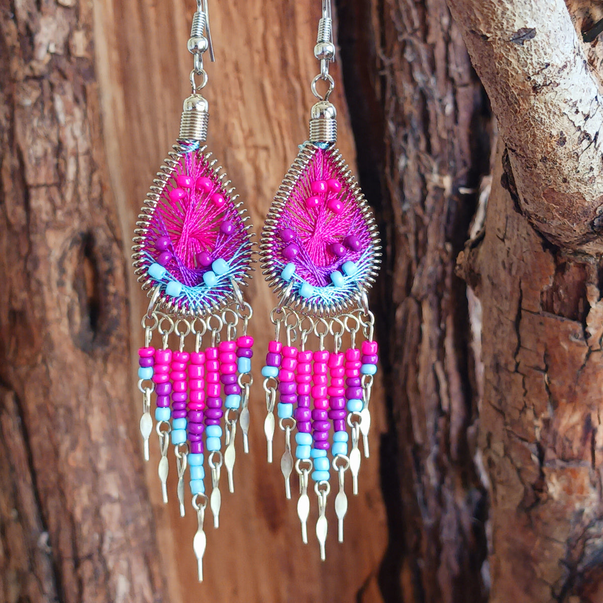 Add a splash of colour to your look with these beautiful handmade Peruvian woven teardrop earrings. Inspired by the vibrant colours and patterns of a peacock feather, each earring features intricate woven detailing complemented by coordinating beads and delicate silver-tone embellishments.