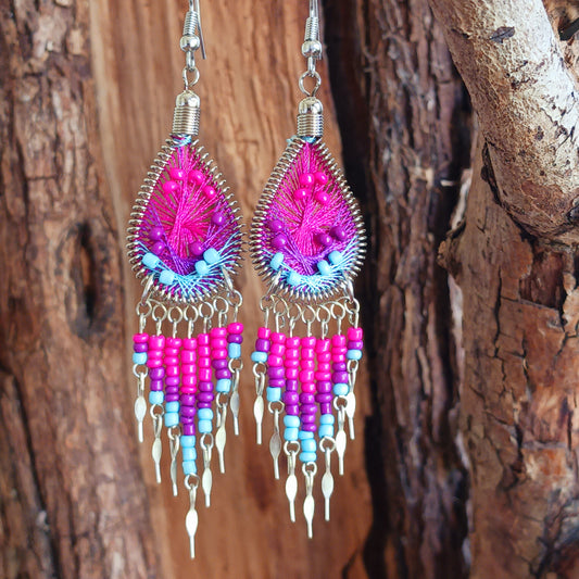 Add a splash of colour to your look with these beautiful handmade Peruvian woven teardrop earrings. Inspired by the vibrant colours and patterns of a peacock feather, each earring features intricate woven detailing complemented by coordinating beads and delicate silver-tone embellishments.
