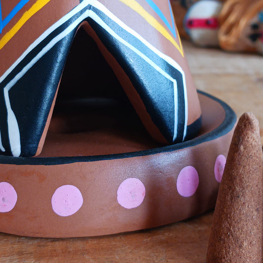 Elevate your incense game with our Clay Tipi Incense Holder.&nbsp;This unique piece has been lovingly handmade and is fairtrade, bringing a touch of charm and authenticity to your home.&nbsp; This quirky tipi design not only catches ash neatly but also adds a playful, earthy vibe to any space. Perfect for meditation, relaxation, or simply creating good vibes and maybe a few smoke signals!
