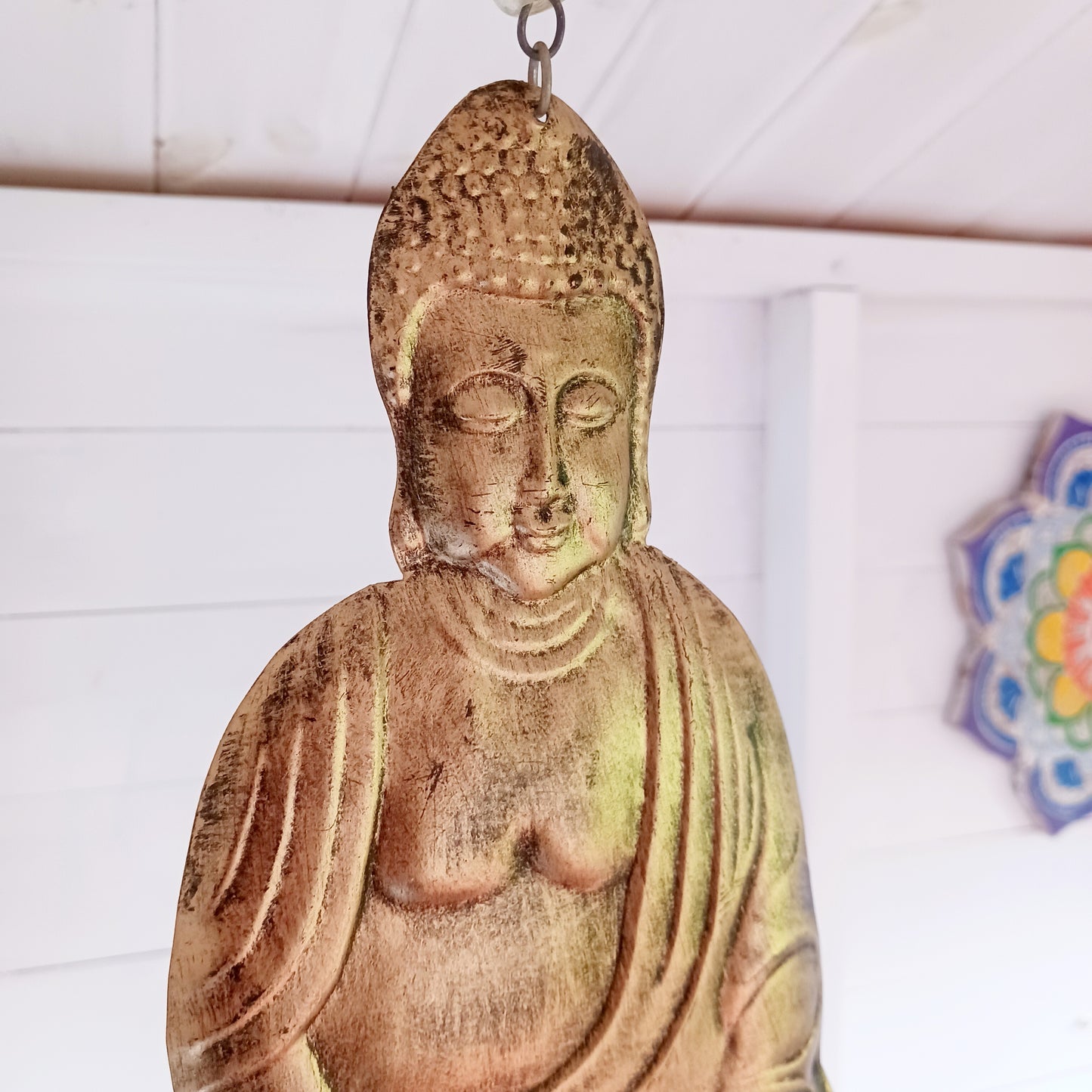 This lovely Buddha 5 bell windchime will bring serenity and cultural charm to any space.  Made in India from brass, this chime features a beautifully detailed Buddha adorned with colourful beads. 
 The five brass bells create a calming melody with every breeze, making it a perfect addition to meditation spaces, gardens, or tranquil home settings.