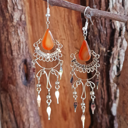 Add a touch of bohemian beauty to your look with these handmade Peruvian stone earrings. Featuring orange stones and finished with silver-plated hooks, each pair is carefully crafted in small workshops in Peru.
