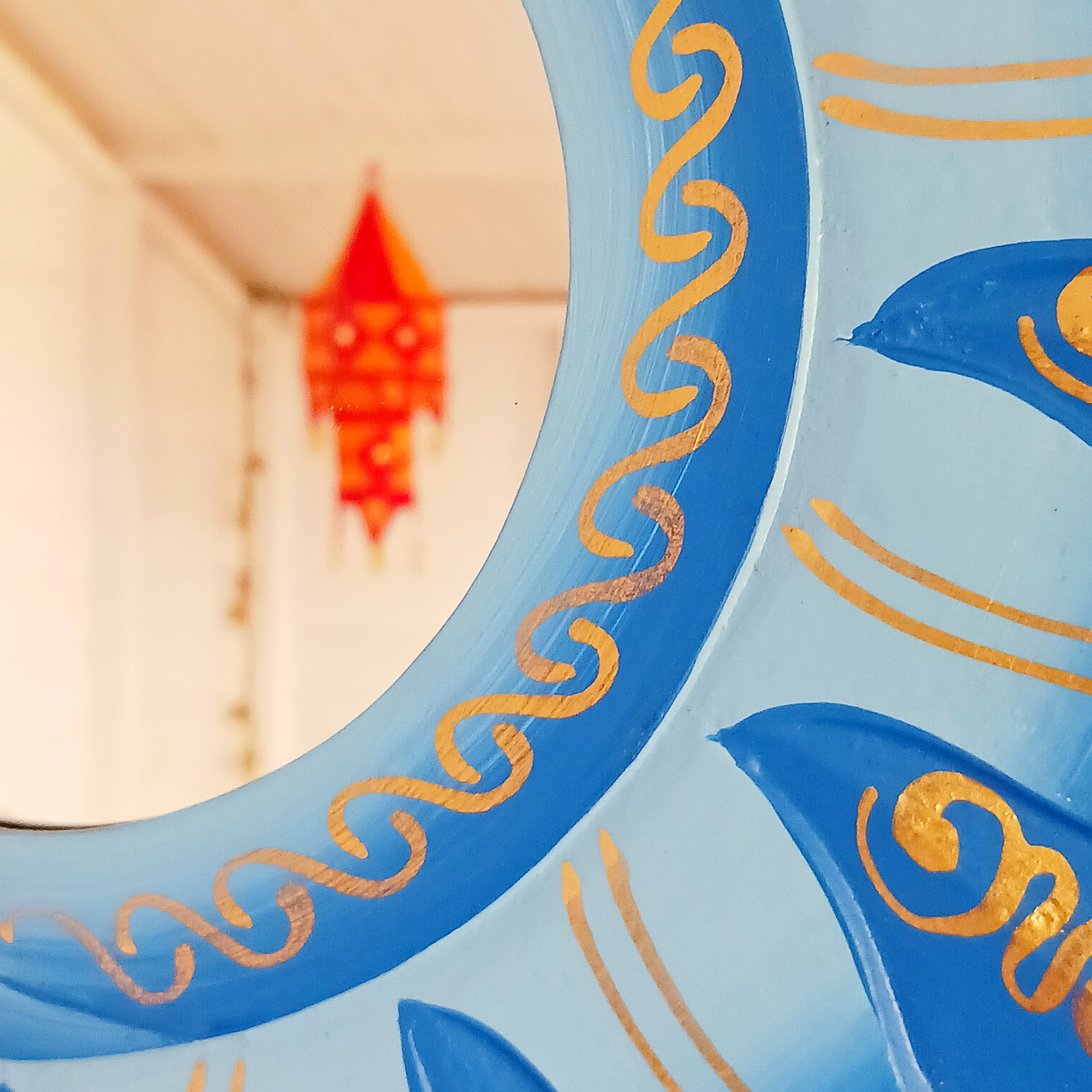 Elevate your home with the mystical charm of our Sun &amp; Moon Mirror. Lovingly handmade by fairtrade artisans, this unique piece features a beautifully painted sun and moon design in vibrant blue tones. Perfect for adding a touch of spirituality, harmony, and positive energy to your living space, this mirror doubles as both a functional piece and captivating art. Ideal for bedrooms, meditation spaces, or as a thoughtful gift for someone special.
