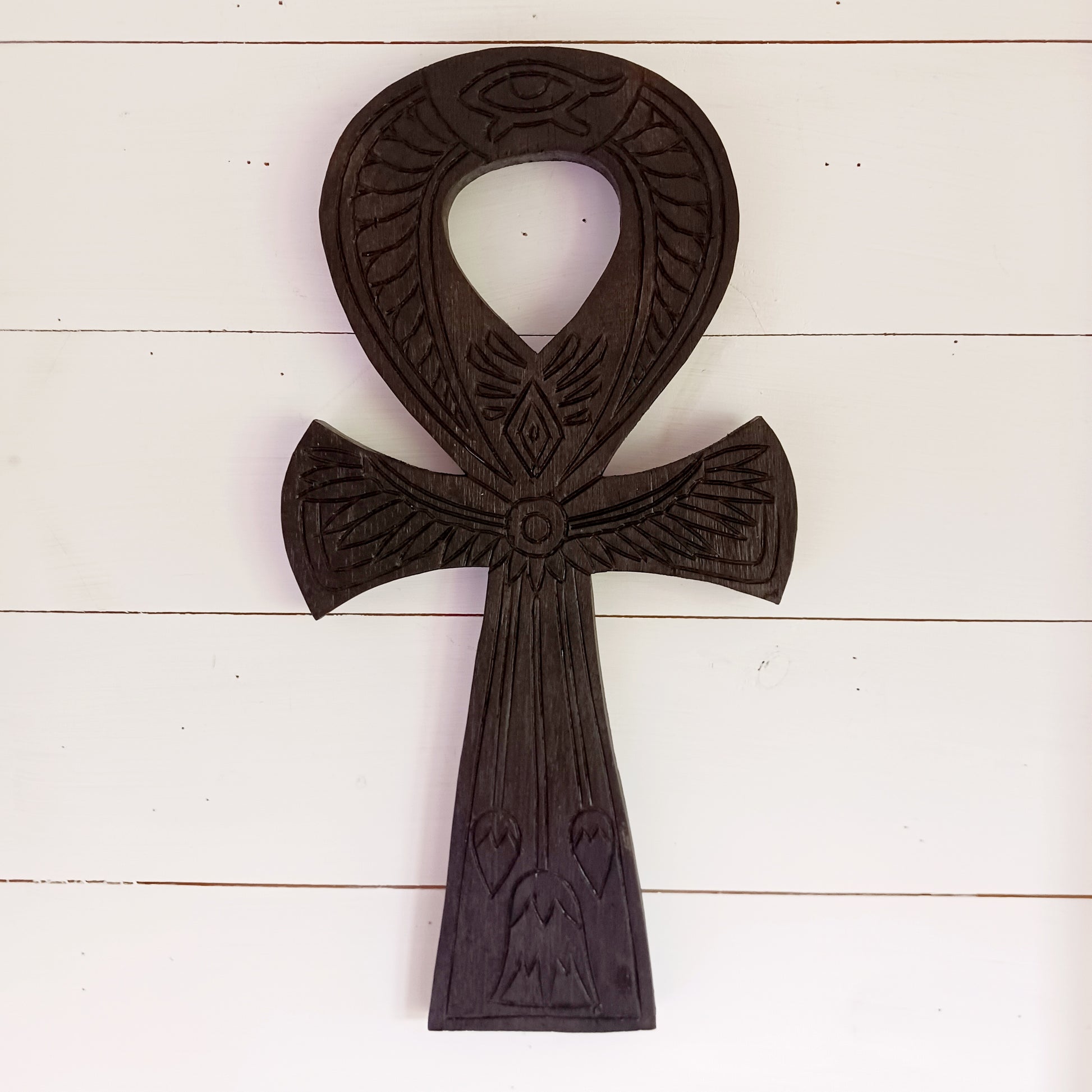 This beautiful and intricately carved wall plaque features a traditional symbol of the ancient Egyptians. The ankh is often interpreted as a symbol of life and eternal existence. Its looped top is thought to represent the eternal soul, while the straight line below symbolises the earthly plane or physical existence. Together, they signify the eternal cycle of life, death, and rebirth.