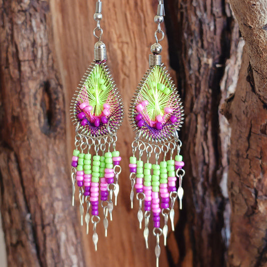 Add a splash of colour to your look with these beautiful handmade Peruvian woven teardrop earrings. Inspired by the vibrant colours and patterns of a peacock feather, each earring features intricate woven detailing complemented by coordinating beads and delicate silver-tone embellishments.