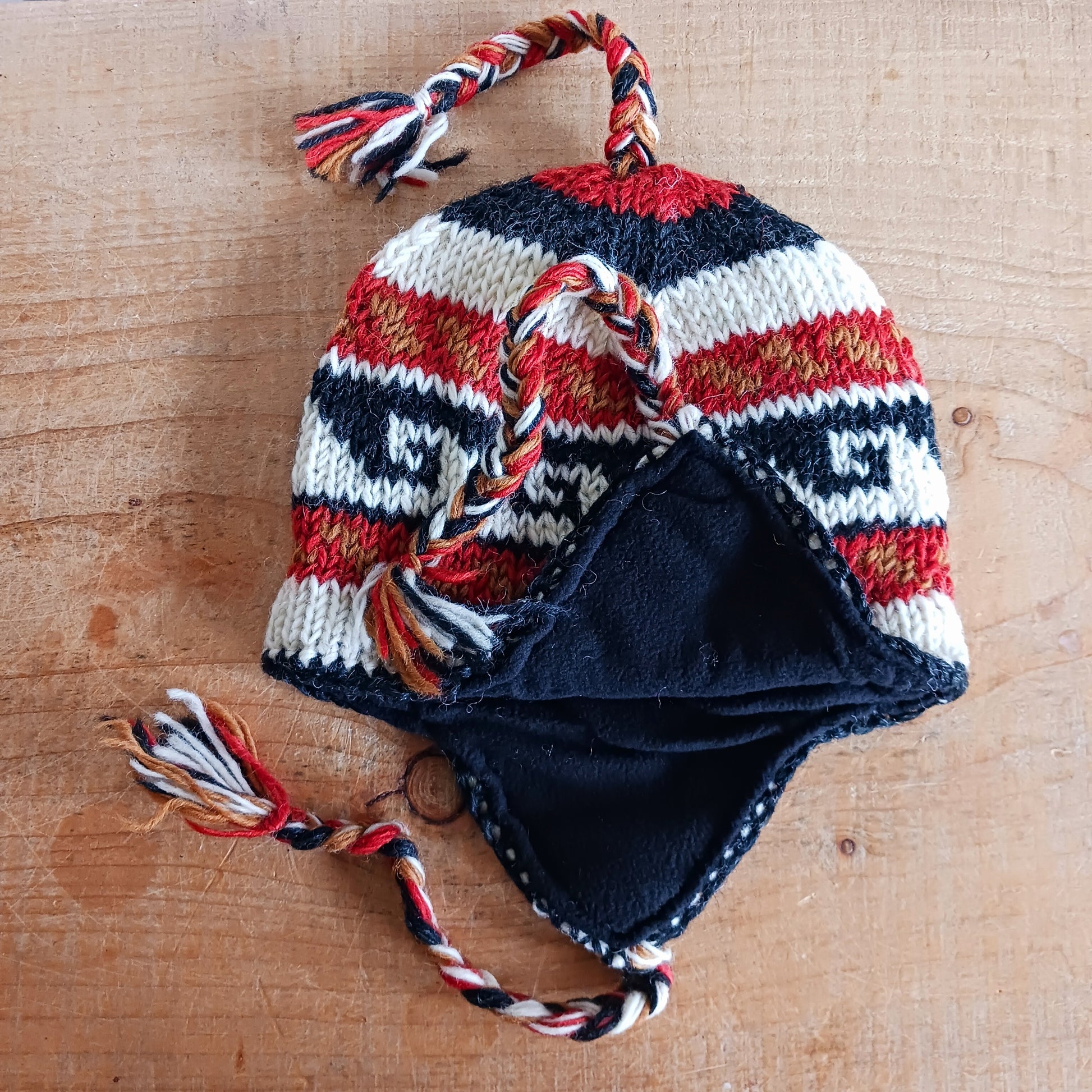 Stay cozy and stylish with our handmade chunky wool earflap hats, crafted in Nepal by skilled women artisans in Kathmandu. Each hat is 100% pure wool and features a soft polar fleece lining for extra warmth and comfort. Perfect for cold winter days, outdoor adventures, or adding a touch of handmade charm to your look.
