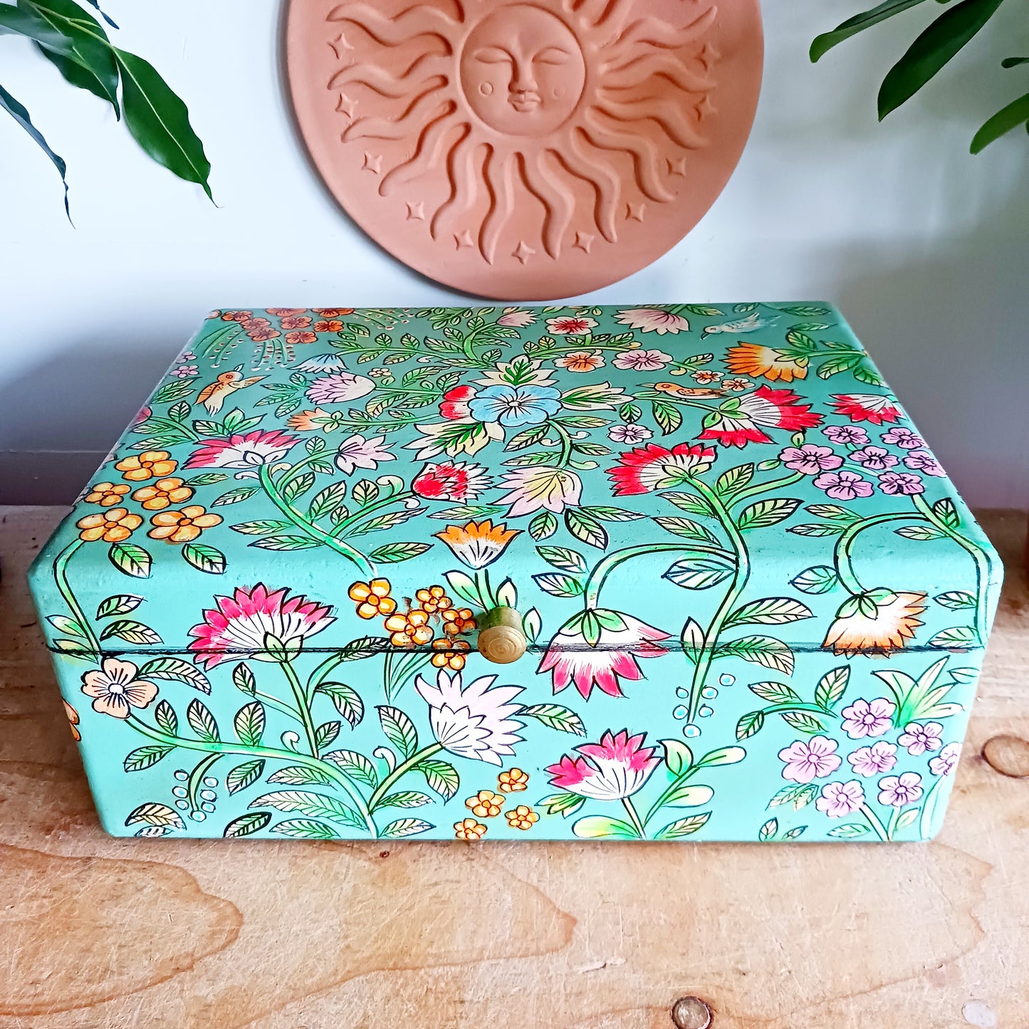 The Saanvi Handcrafted Large Wooden Box is a sustainable gift of beauty, designed to bring charm and practicality to any space. Expertly hand-painted in a bright mixed floral pattern on a pale blue background, this decorative box exudes artisanal elegance.
