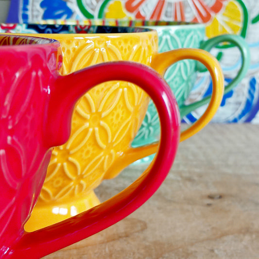 Bring Mediterranean charm to your kitchen with these beautiful Tuscany-inspired ceramic mugs. Featuring a vibrant glaze outside and embossed geometric patterns inside, they capture the rustic warmth of terracotta tiles and intricate murals found in sun-soaked Italian villages. The kaleidoscopic interiors add a burst of artistic flair, making them perfect for your morning coffee or evening tea. Stylish and versatile, these mugs are a thoughtful gift or a delightful treat for yourself.