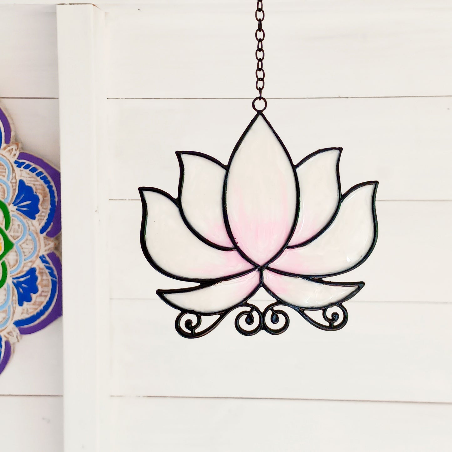 Bring a touch of tranquility to your space with this beautifully crafted lotus flower window hanger. Made from coloured glass and outlined in sleek metal framing, this piece combines simplicity and elegance. When sunlight passes through, it creates a radiant, uplifting display of colour. Hang it in any window to inspire peace, mindfulness, and beauty in your home or workspace.