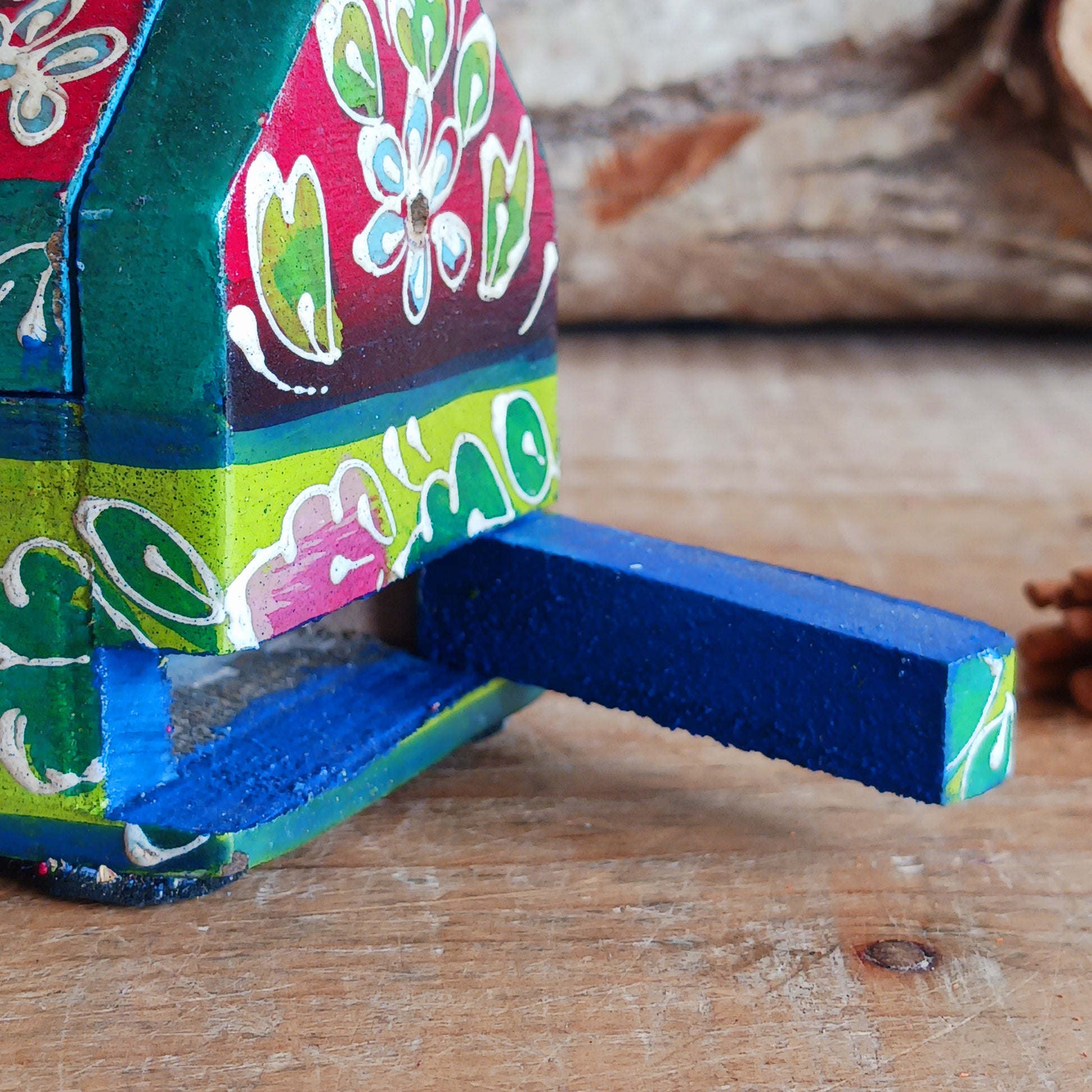 This beautiful pink and green wooden Incense box has been hand painted and has a curved hinged lid. It can accommodate both incense sticks and cones. There is also a place for you to safely store your incense sticks at the bottom on the box.