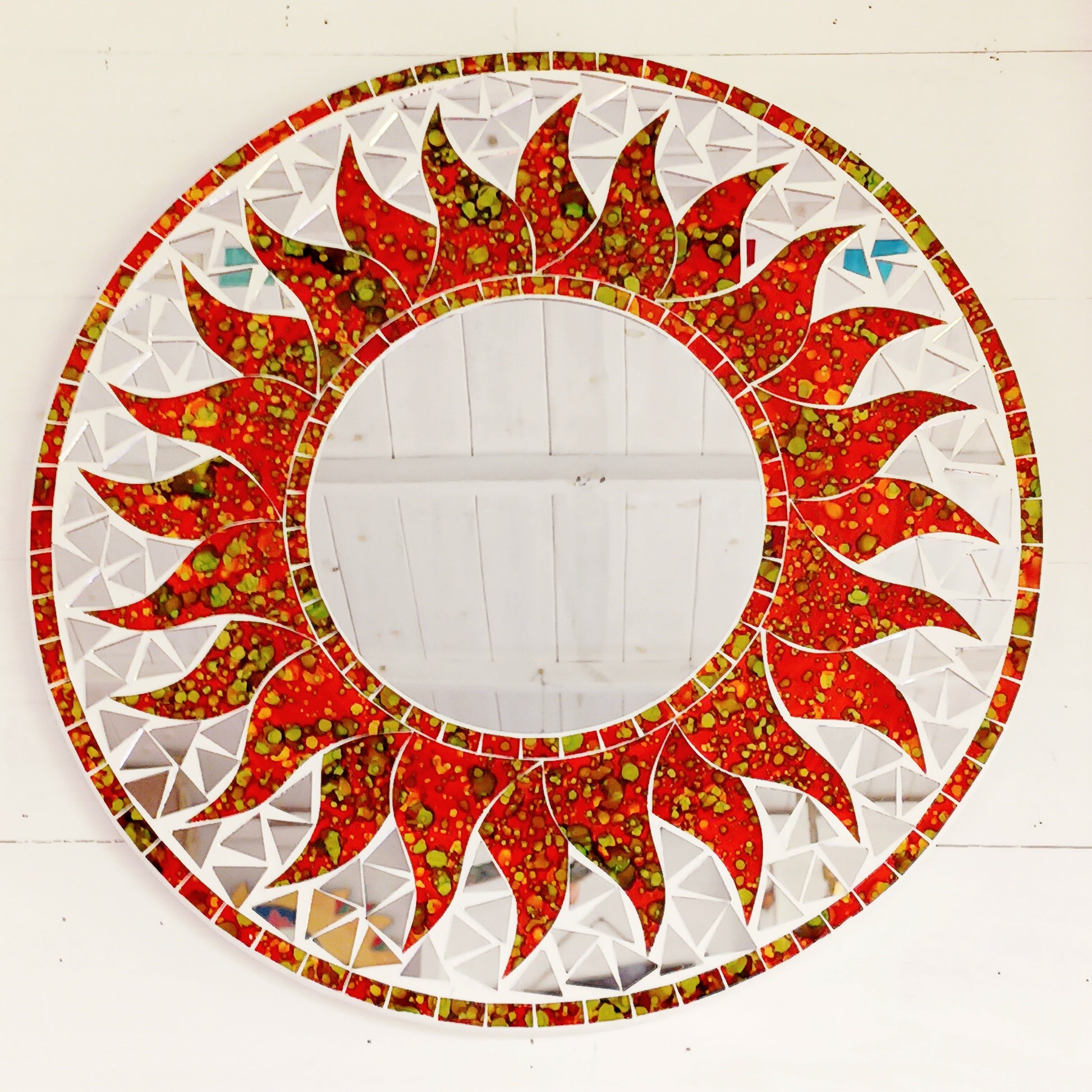 dd warmth, energy, and artistic charm to your home with this beautiful Vibrant Orange Mosaic Sun Mirror. Designed with dazzling orange mosaic tiles arranged in a radiant sunburst pattern, this captivating wall accent instantly brightens any room. 