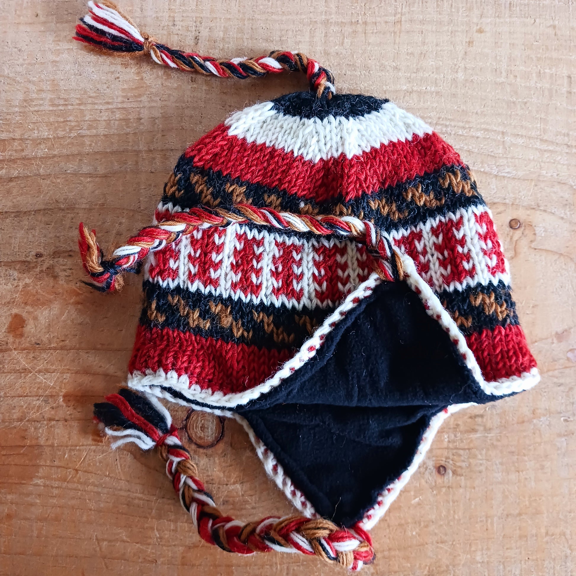 Stay cozy and stylish with our handmade chunky wool earflap hats, crafted in Nepal by skilled women artisans in Kathmandu. Each hat is 100% pure wool and features a soft polar fleece lining for extra warmth and comfort. Perfect for cold winter days, outdoor adventures, or adding a touch of handmade charm to your look.