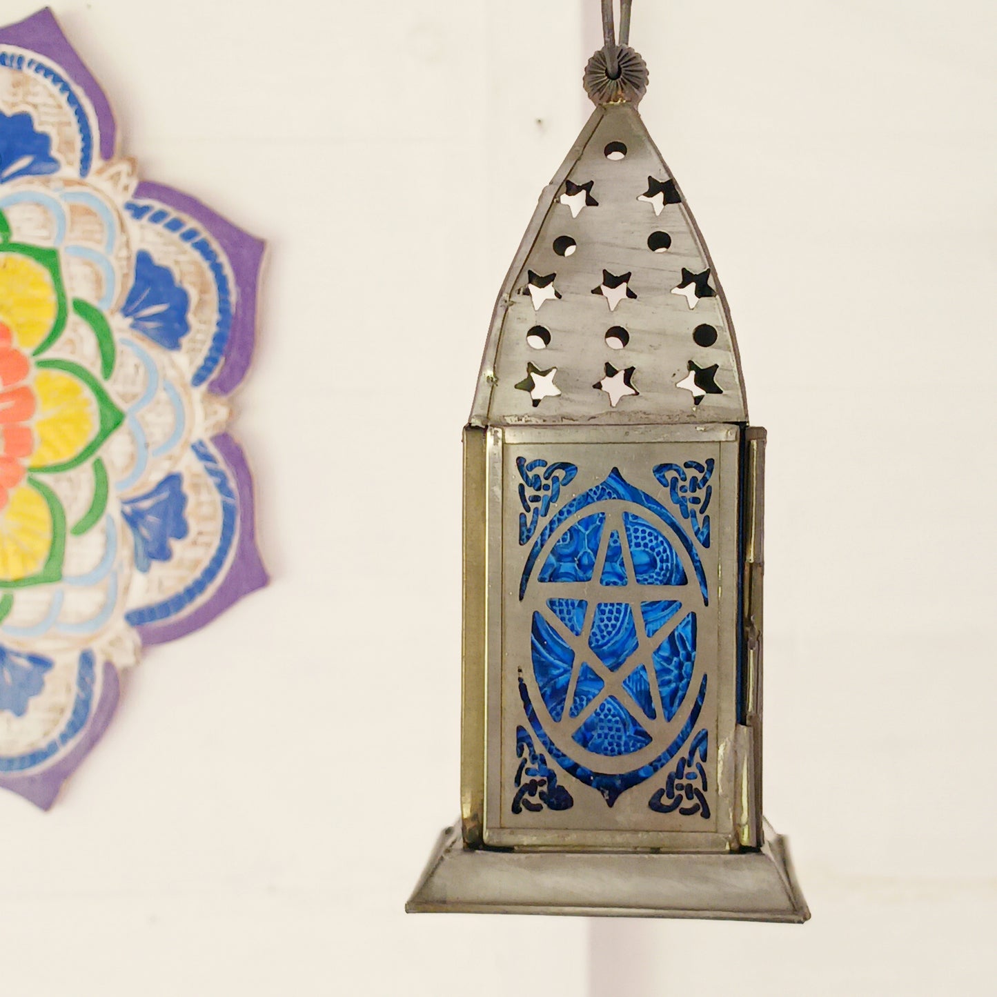 Bring warmth, colour and spiritual harmony to your home with this beautiful Pentagram Glass Lantern. Designed with vibrant coloured glass panels and a decorative metal cut-out canopy, this lantern creates a calming glow that enhances meditation spaces, yoga rooms and home décor.