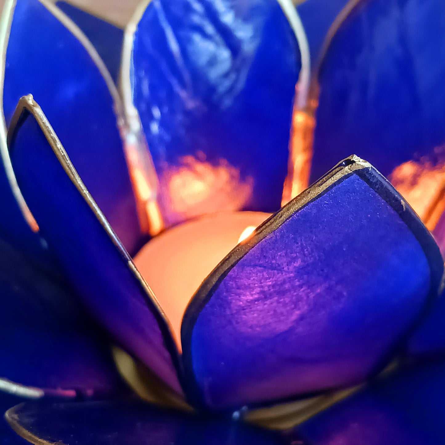 Illuminate your space with the peaceful elegance of our Capiz Shell Lotus Flower Candle Holder. Symbolizing enlightenment and serenity, this stunning handcrafted piece features delicate blue petals edged in gold, forming the iconic lotus shape.