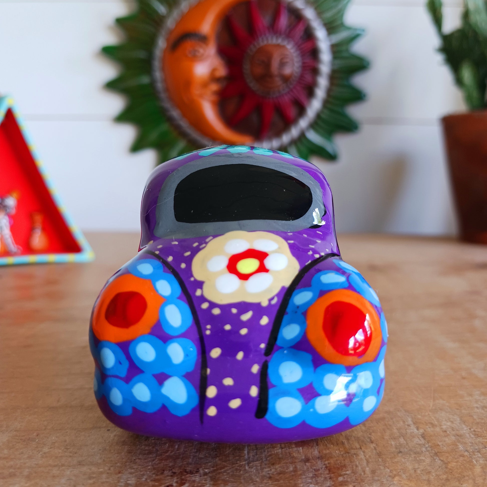 This fun little VW car ornament oozes retro vibes. With it's bold flower power design and vibrant colours it will brighten up any sideboard. This type of car, affectionately known as a 'bochito', are very popular in Mexico due to their reliability when driving about steep roads. Incidentally, the Mexican town of Puebla was home to the last Beetle production factory which only closed in 2003.