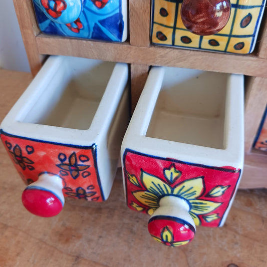 Add a touch of authentic Indian craftsmanship to your home with this Handcrafted Indian Ceramic 16-Drawer Mini Chest. Featuring 16 individually hand-painted ceramic drawers set within a warm wooden frame, this decorative storage cabinet is both practical and beautifully unique.