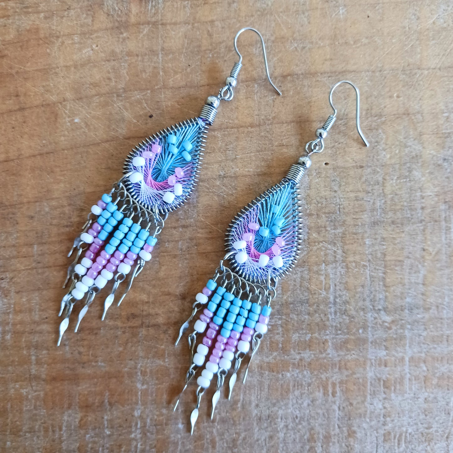 Add a splash of colour to your look with these beautiful handmade Peruvian woven teardrop earrings. Inspired by the vibrant colours and patterns of a peacock feather, each earring features intricate woven detailing complemented by coordinating beads and delicate silver-tone embellishments.