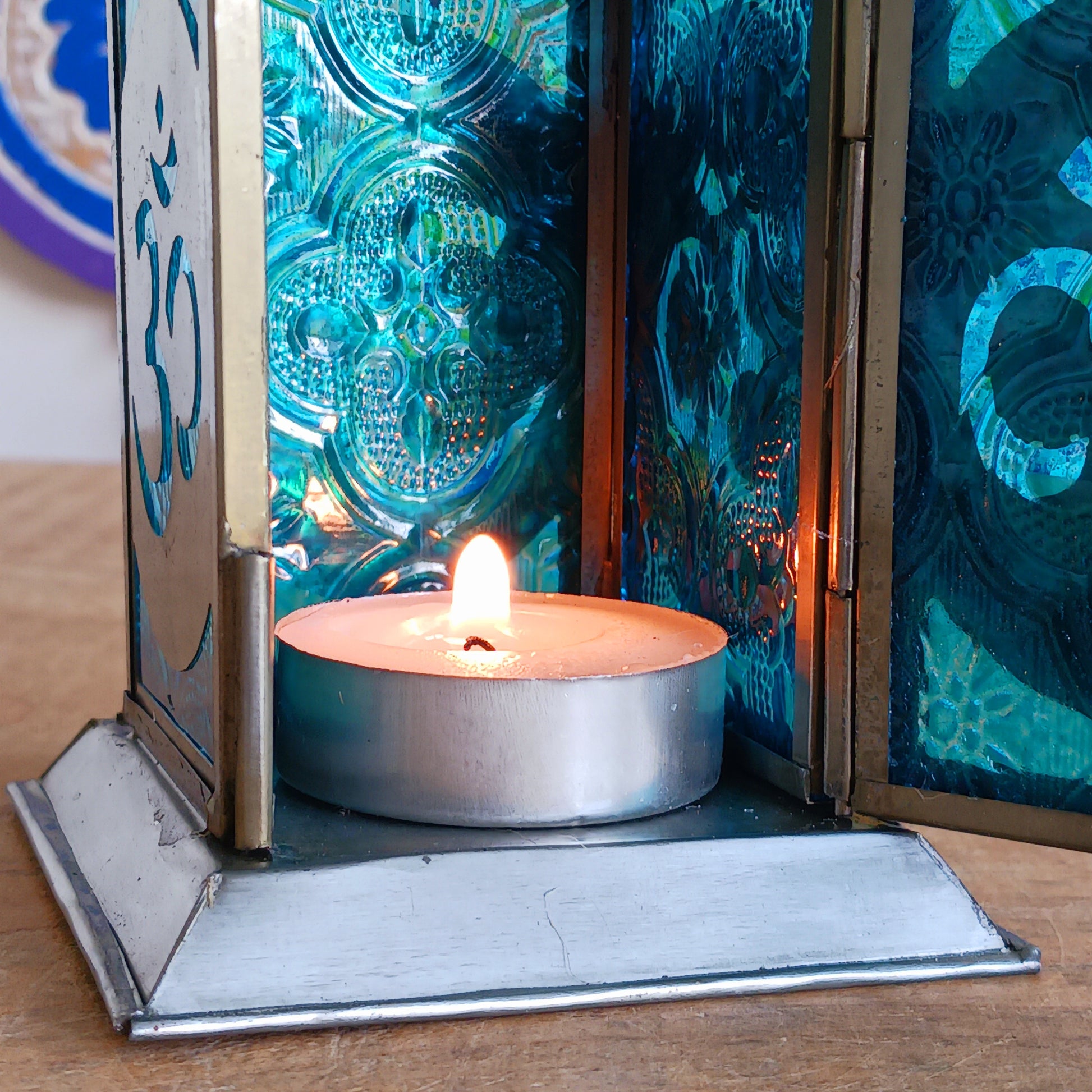 Bring warmth, colour and spiritual harmony to your home with this beautiful Om Symbol Glass Lantern. Designed with vibrant coloured glass panels and a decorative metal cut-out canopy, this lantern creates a calming glow that enhances meditation spaces, yoga rooms and home décor.