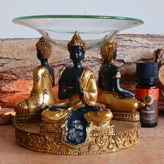 Create a calm and peaceful atmosphere in your home with this Gold &amp; Brown Buddha Oil &amp; Wax Burner featuring beautiful glass mosaic detailing. Designed with three Buddha figures arranged in a circular design, this decorative burner brings a sense of serenity and spiritual elegance to any room.