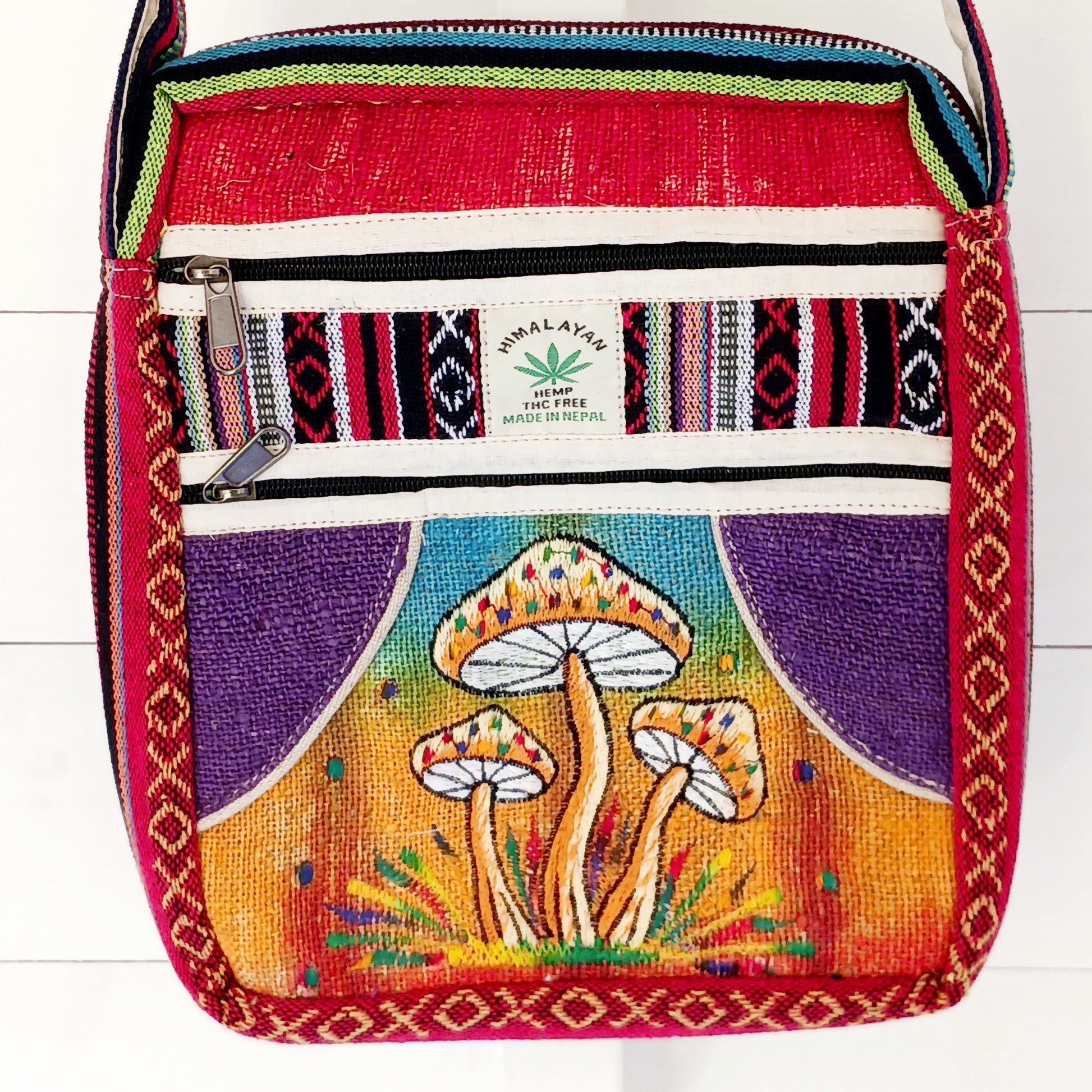 This is such a fantastic and handy messenger bag or satchel. Made from hemp with cotton lining, this bag is beautifully crafted featuring lots of handy compartments. On the front are three colourful and embroidered mushrooms.