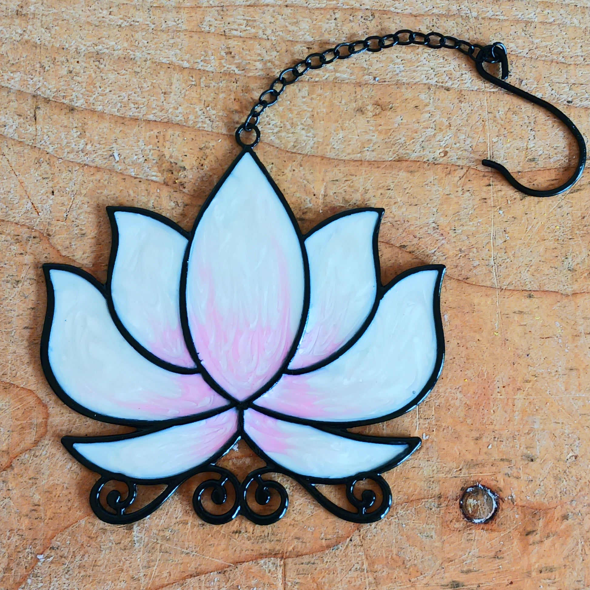 Bring a touch of tranquility to your space with this beautifully crafted lotus flower window hanger. Made from coloured glass and outlined in sleek metal framing, this piece combines simplicity and elegance. When sunlight passes through, it creates a radiant, uplifting display of colour. Hang it in any window to inspire peace, mindfulness, and beauty in your home or workspace.