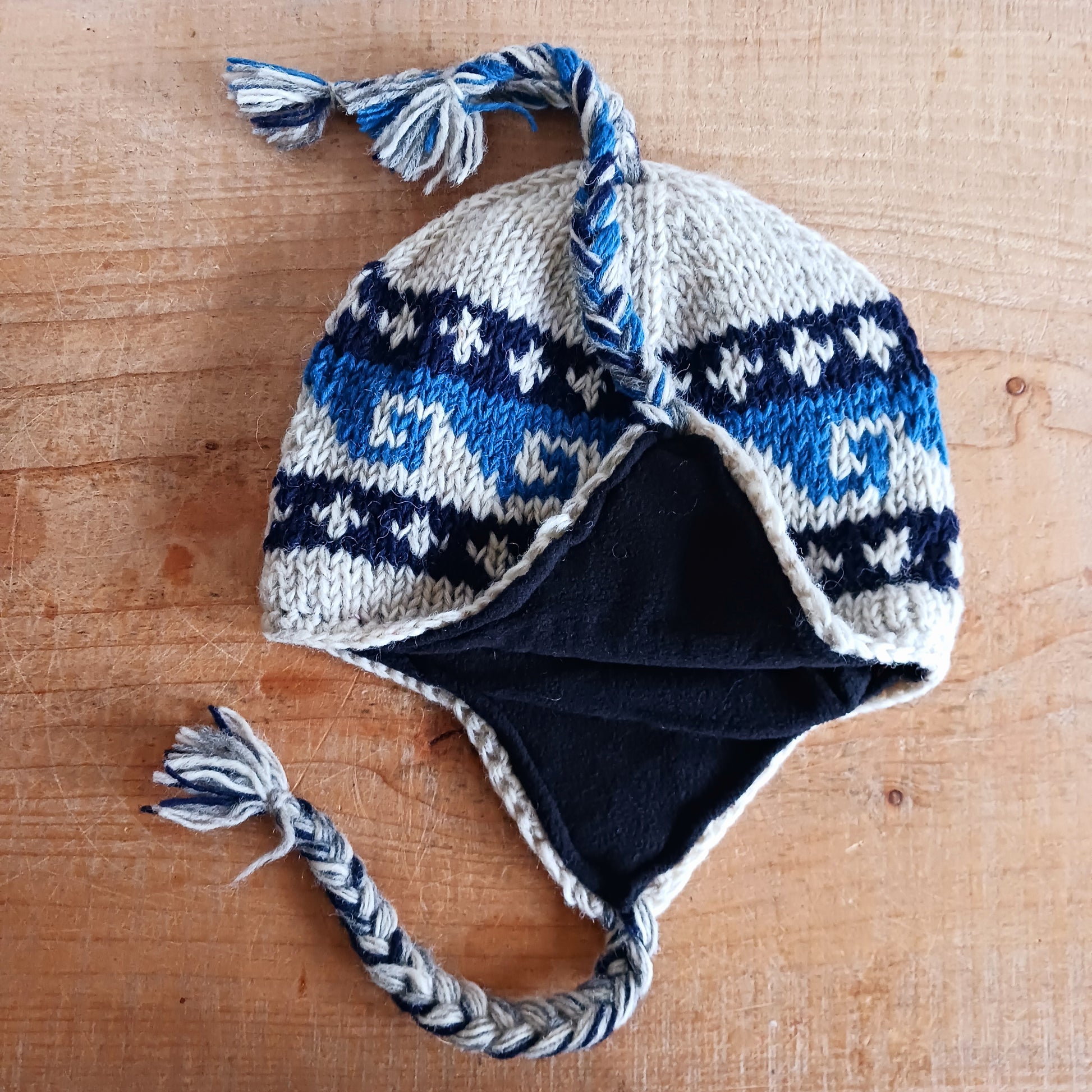 Stay cozy and stylish with our handmade chunky wool earflap hats, crafted in Nepal by skilled women artisans in Kathmandu. Each hat is 100% pure wool and features a soft polar fleece lining for extra warmth and comfort. Perfect for cold winter days, outdoor adventures, or adding a touch of handmade charm to your look.
