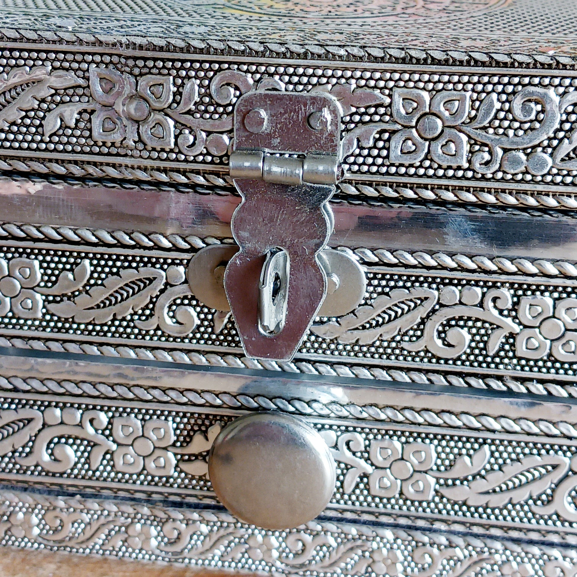 This beautiful silver colour embossed aluminium jewellery box has plenty of space for you to keep you jewellery and other valueables, and comes with a pull-out drawer.  It is lined with black cotton velvet and intricately decorated with a hamsa hand on the lid, and ornate bordering.
