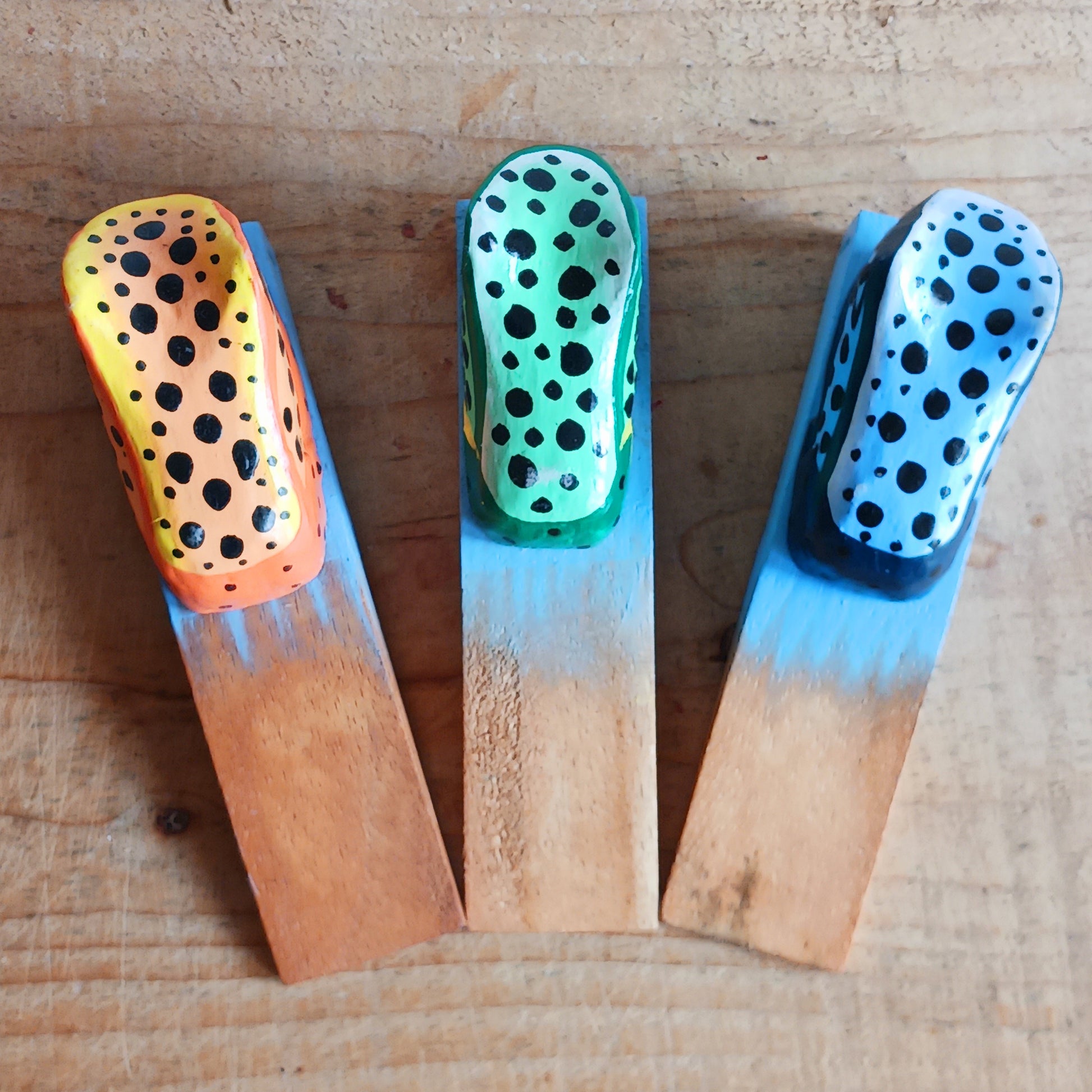 Bring charm and character into your home with this decorative wooden door stopper, featuring a turquoise base and a playful, hand-painted dotty frog design in vibrant blue, green, and orange. Perfect for propping open doors in style, this quirky wedge door stop is both practical and fun.