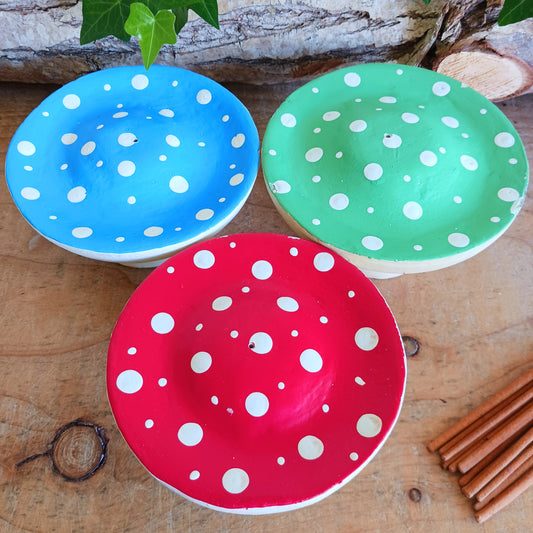 Bring woodland charm to your space with these hand-painted wooden mushroom incense holders. Each piece features a white stalk and a vibrant, spotty cap in your choice of blue, green or red. Designed with a central incense stick holder, these mushrooms are perfect for adding a whimsical, on-trend touch to your décor.