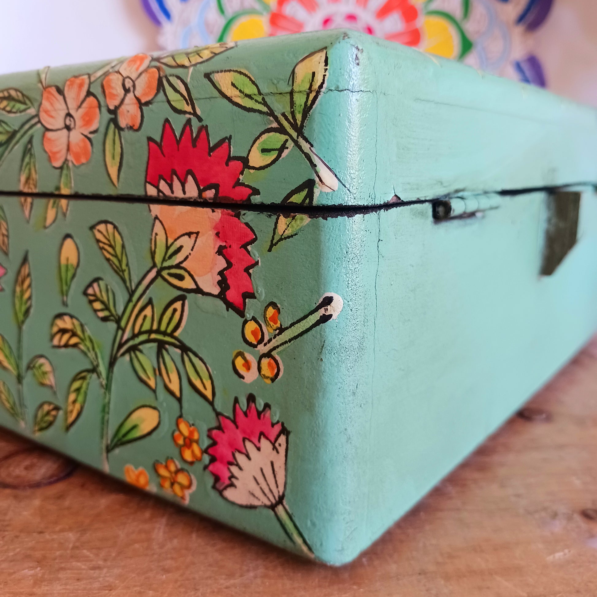 The Saanvi Handcrafted Large Wooden Box is a sustainable gift of beauty, designed to bring charm and practicality to any space. Expertly hand-painted in a bright mixed floral pattern on a pale blue background, this decorative box exudes artisanal elegance. The hinged lid is accented with a small gold-colored knob for a refined touch, while the deep midnight interior offers ample storage for trinkets, jewellery, and cherished keepsakes.