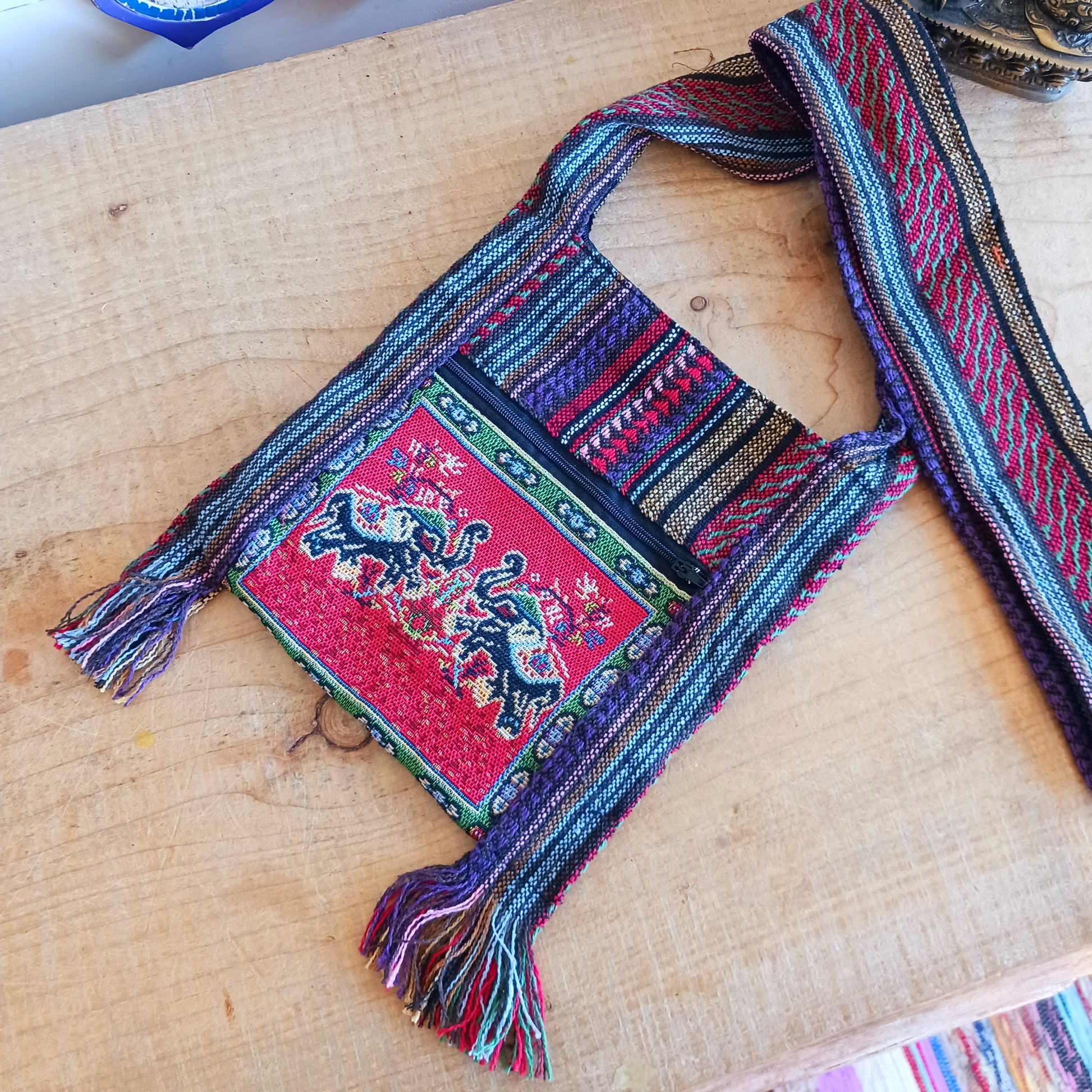 This handy little shoulder bag has a wide strap that is long enough to use as a shoulder or crossbody bag and also makes it comfortable to wear for long periods. The main fabric is traditional with a beautiful embroidered decorated elephants on the front. The bag is finished with tassels.