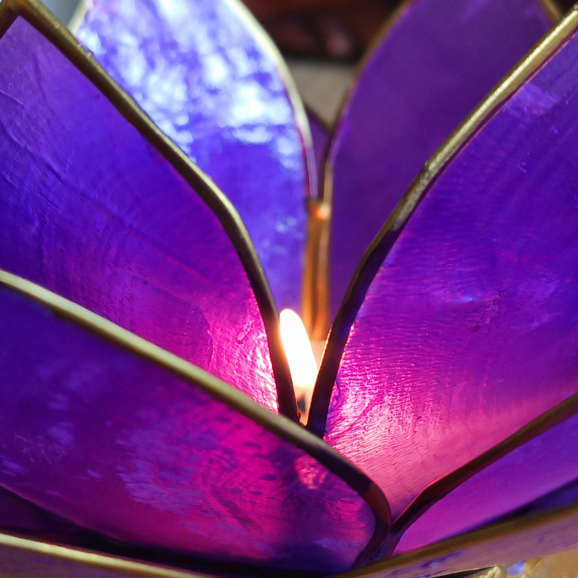 Illuminate your space with the peaceful elegance of our Capiz Shell Lotus Flower Candle Holder. Symbolizing enlightenment and serenity, this stunning handcrafted piece features delicate purple petals edged in gold, forming the iconic lotus shape. When lit, the layered design diffuses candlelight into a soft, radiant glow — ideal for creating a calming ambiance indoors or outdoors.