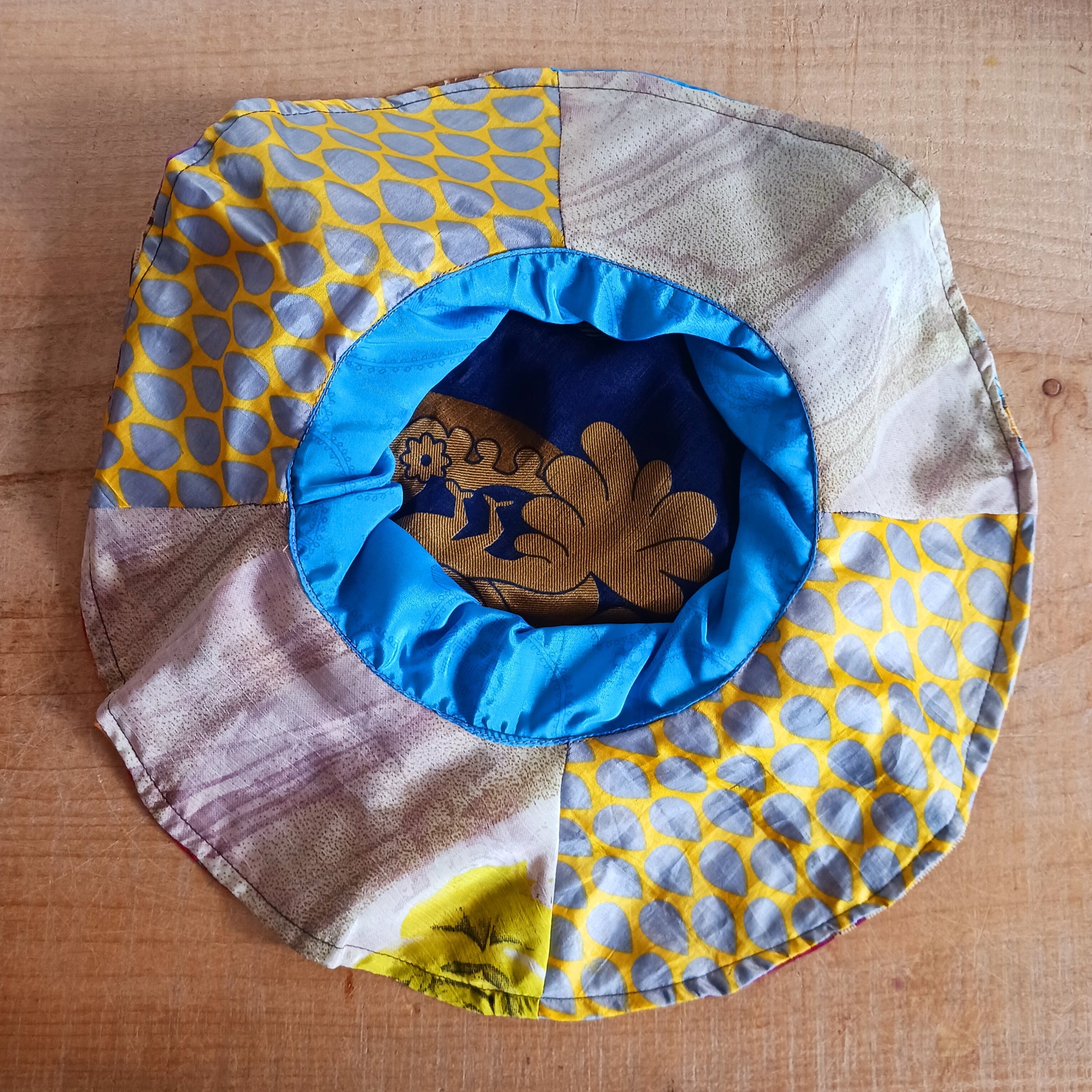 This colourful sunhat is made from patches of remnants from saris. Each hat is unique and features a wide brim to keep the sun from your face and keep you cool, lined with plain cotton to keep you even cooler. These hats are lightweight so easy to carry around in your bag. Ideal for travelling and festivals.
