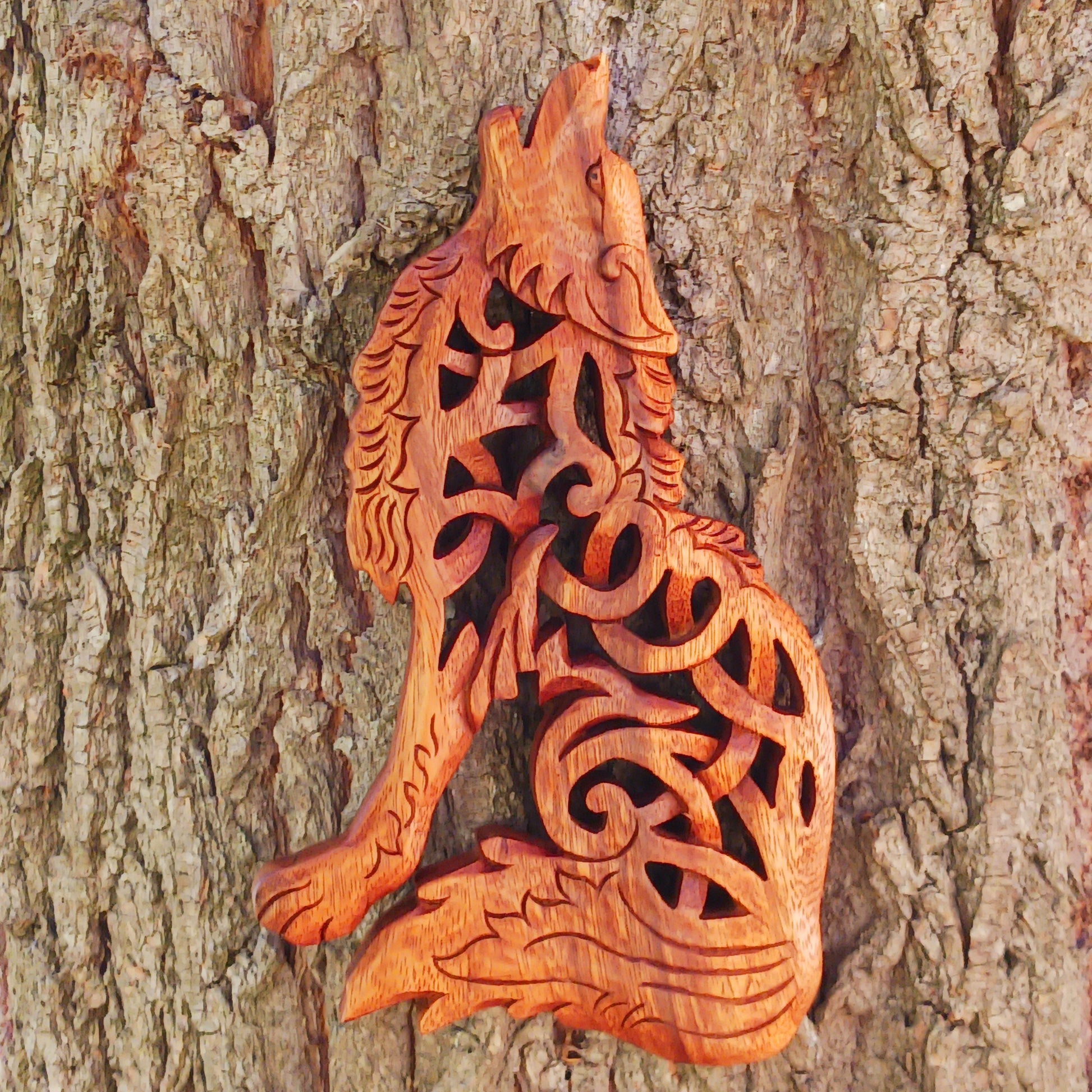Bring the spirit of the wild into your home with this beautiful and striking Howling Wolf Celtic Knotwork Wooden Plaque. Hand-carved by skilled artisans in Bali, this open-work wooden wall plaque features an upright wolf with its head thrown back in a powerful howl.