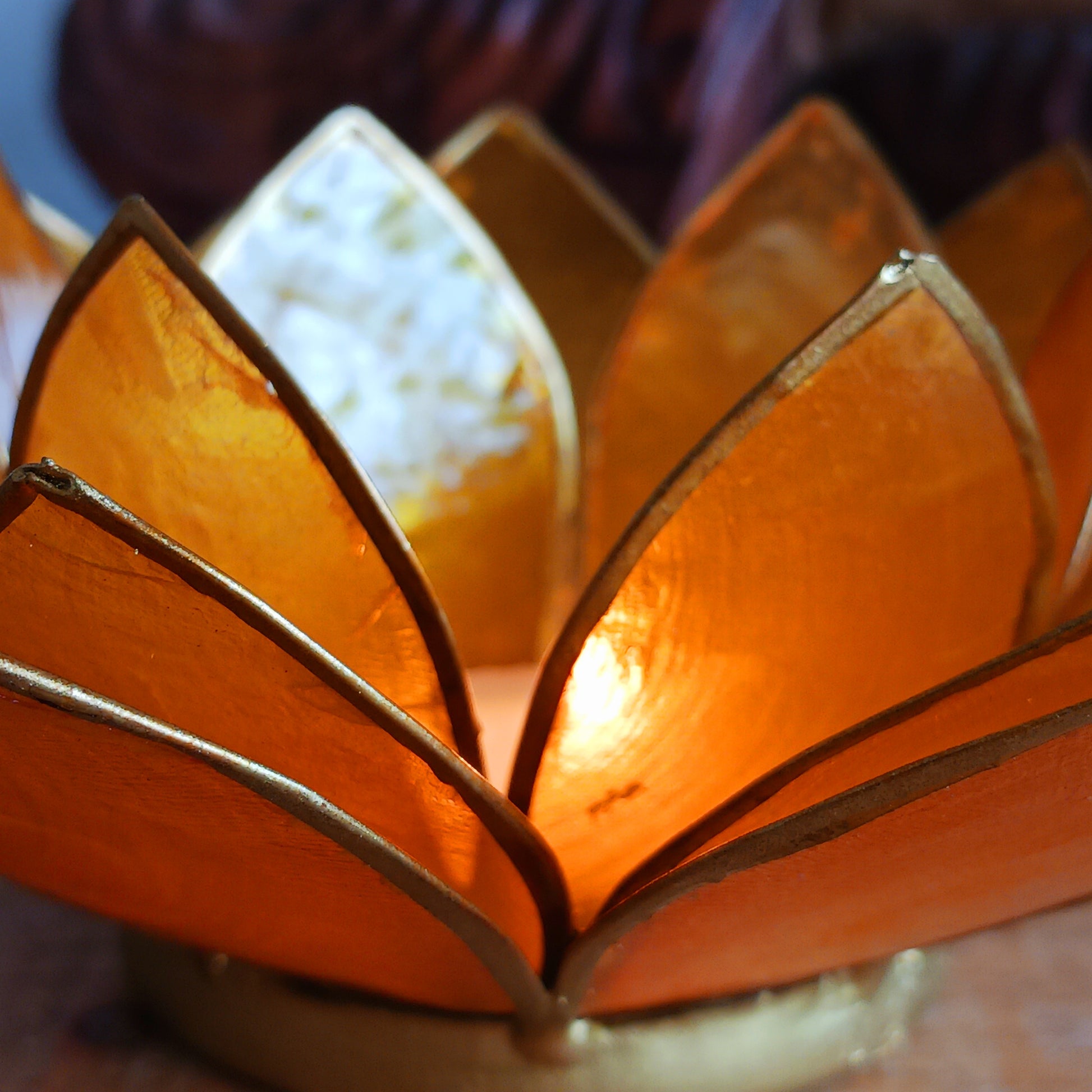 Illuminate your space with the peaceful elegance of our Capiz Shell Lotus Flower Candle Holder. Symbolizing enlightenment and serenity, this stunning handcrafted piece features delicate yellow petals edged in gold, forming the iconic lotus shape.