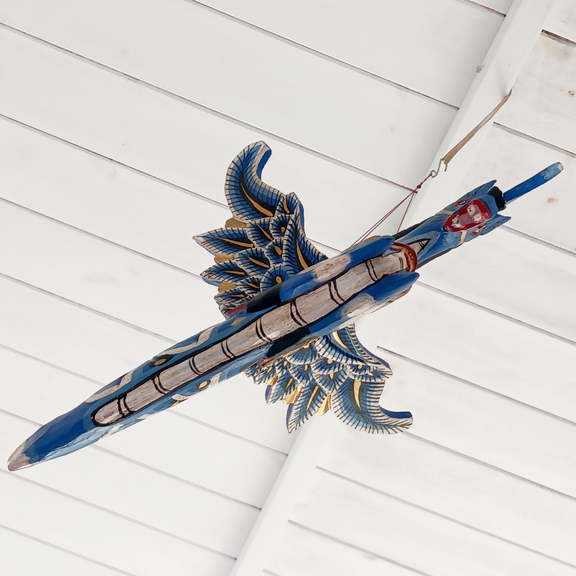 Bring a touch of fantasy to your home with this beautifully handcrafted winged seahorse hanging mobile. Hand-painted in vivid cobalt blue, this enchanting wooden seahorse features intricate painted scales, feather-like detailing and traditional Balinese-inspired decoration.