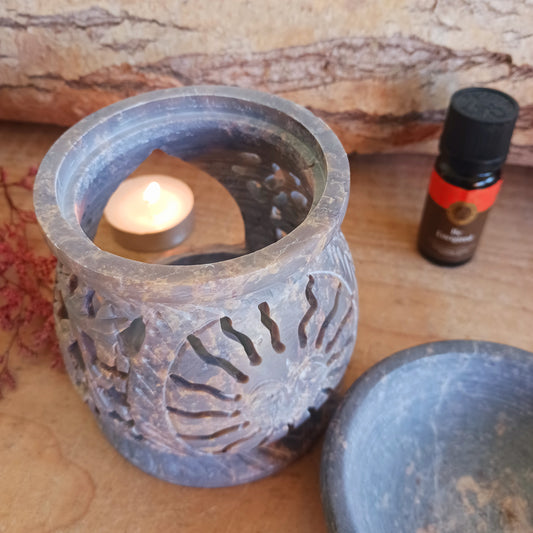 Enhance your home with calming fragrance and natural style with this beautifully carved soapstone oil burner. Featuring an elegant central sun motif with detailed leaf designs, this decorative aromatherapy burner adds warmth, ambience, and relaxing scent to any room.