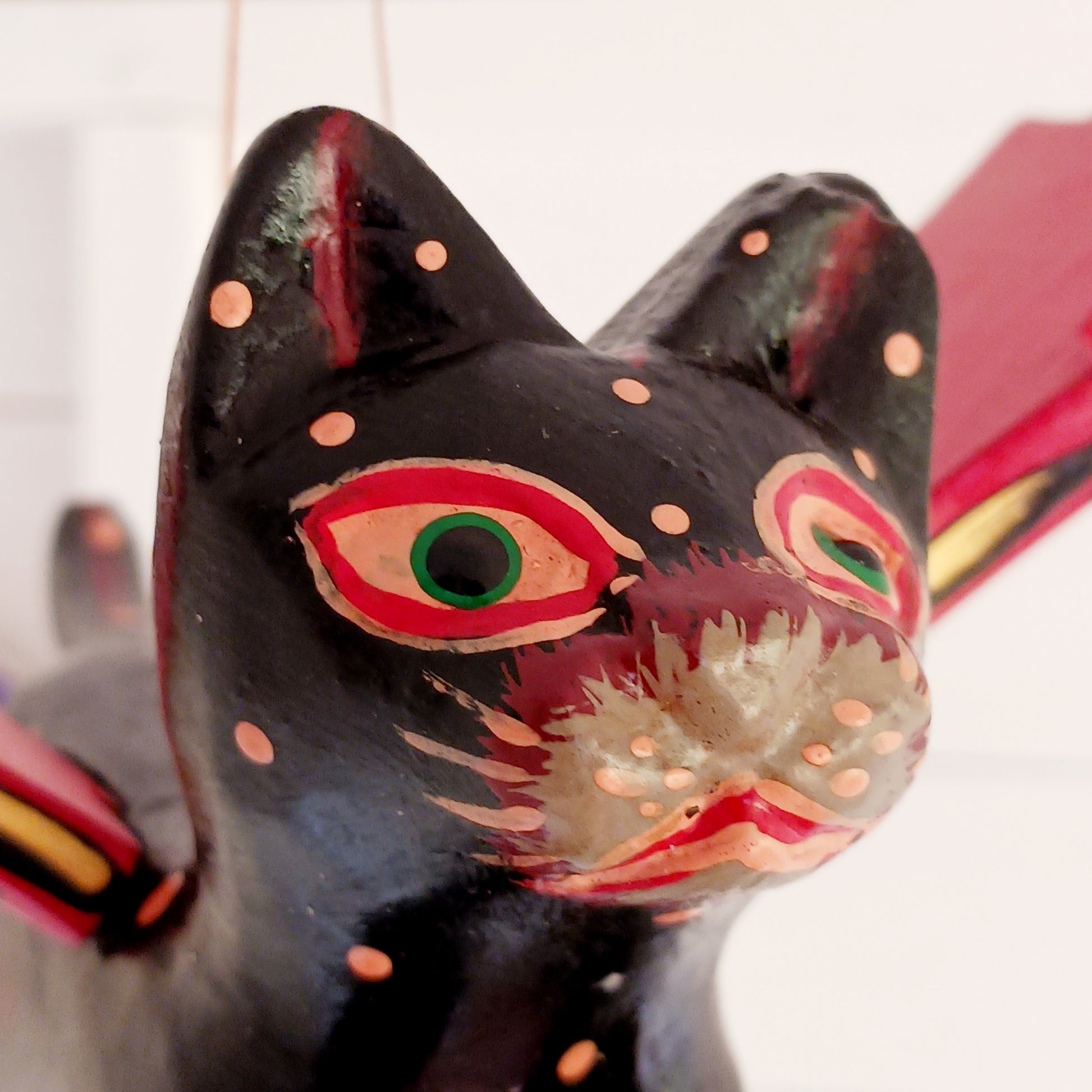Bring a touch of mystery and magical drama to your home with this striking flying cat mobile, hand carved and painted by skilled artisans in Bali. Featuring a deep black cat with vivid red wings and intricate painted detailing, this unusual hanging decoration makes a bold statement wherever it is displayed.