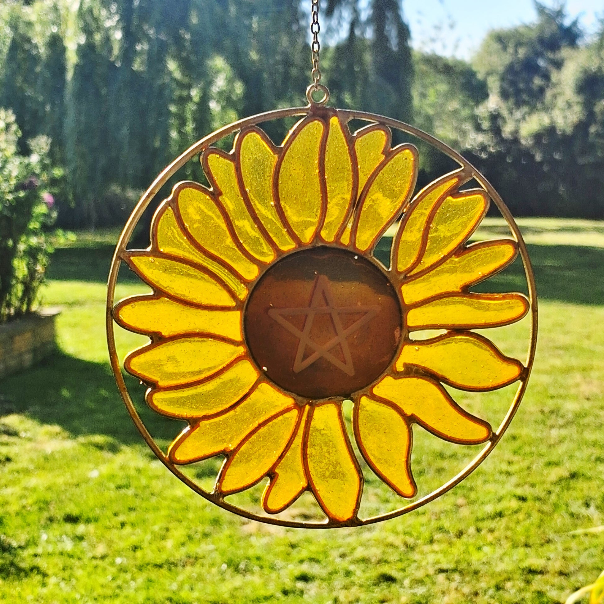 Add a touch of sunshine to the home with this Summer Solstice sunflower suncatcher. This charming suncatcher is inspired by the Summer Solstice, featuring a beautifully detailed sunflower, pentagram, star and crescent moon design made from metal and resin. Hang it in the window to catch the light and bring a cheerful, colourful glow to any room.
