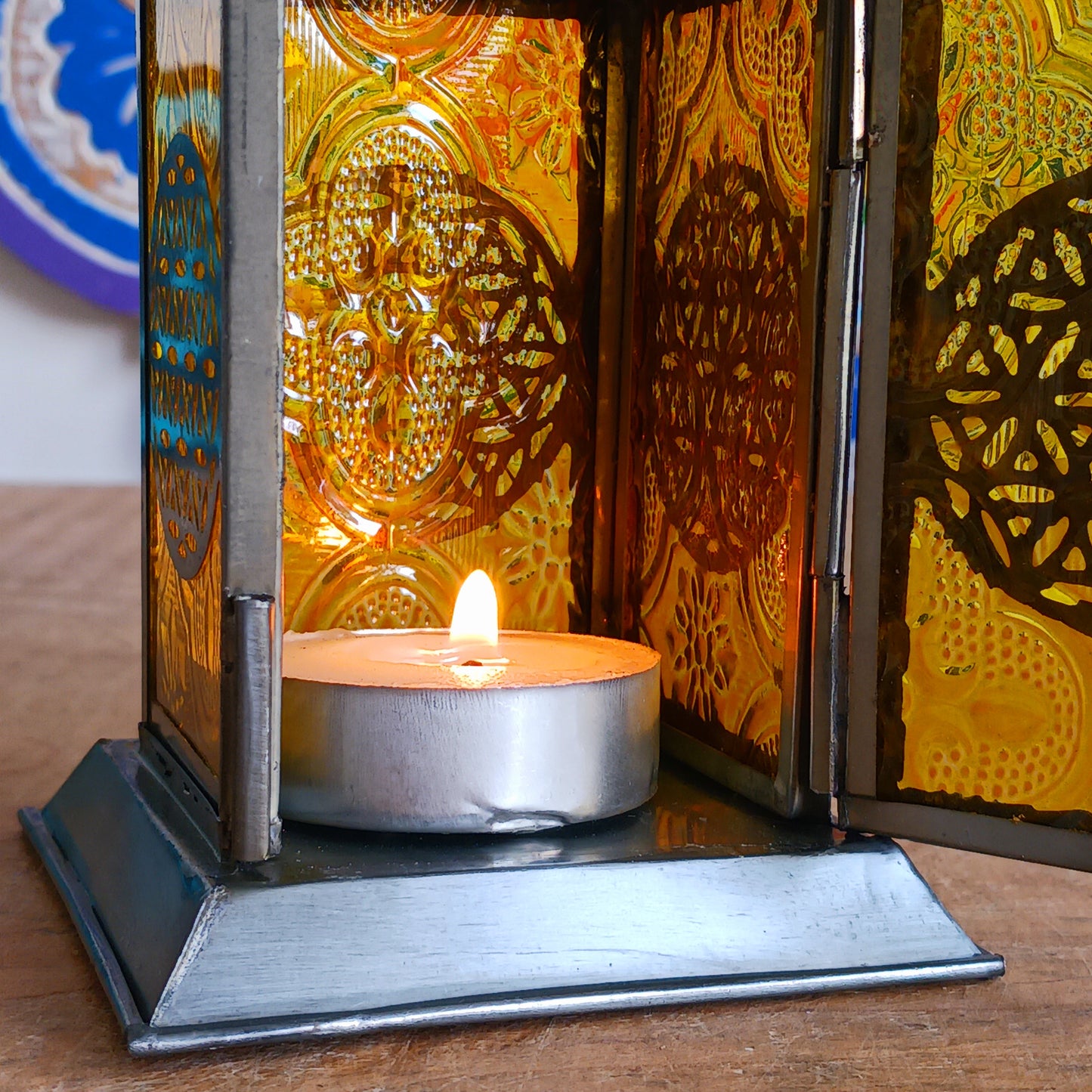 Bring warmth, colour and spiritual harmony to your home with this beautiful Tree of Life Glass Lantern. Designed with vibrant coloured glass panels and a decorative metal cut-out canopy, this lantern creates a calming glow that enhances meditation spaces, yoga rooms and home décor.