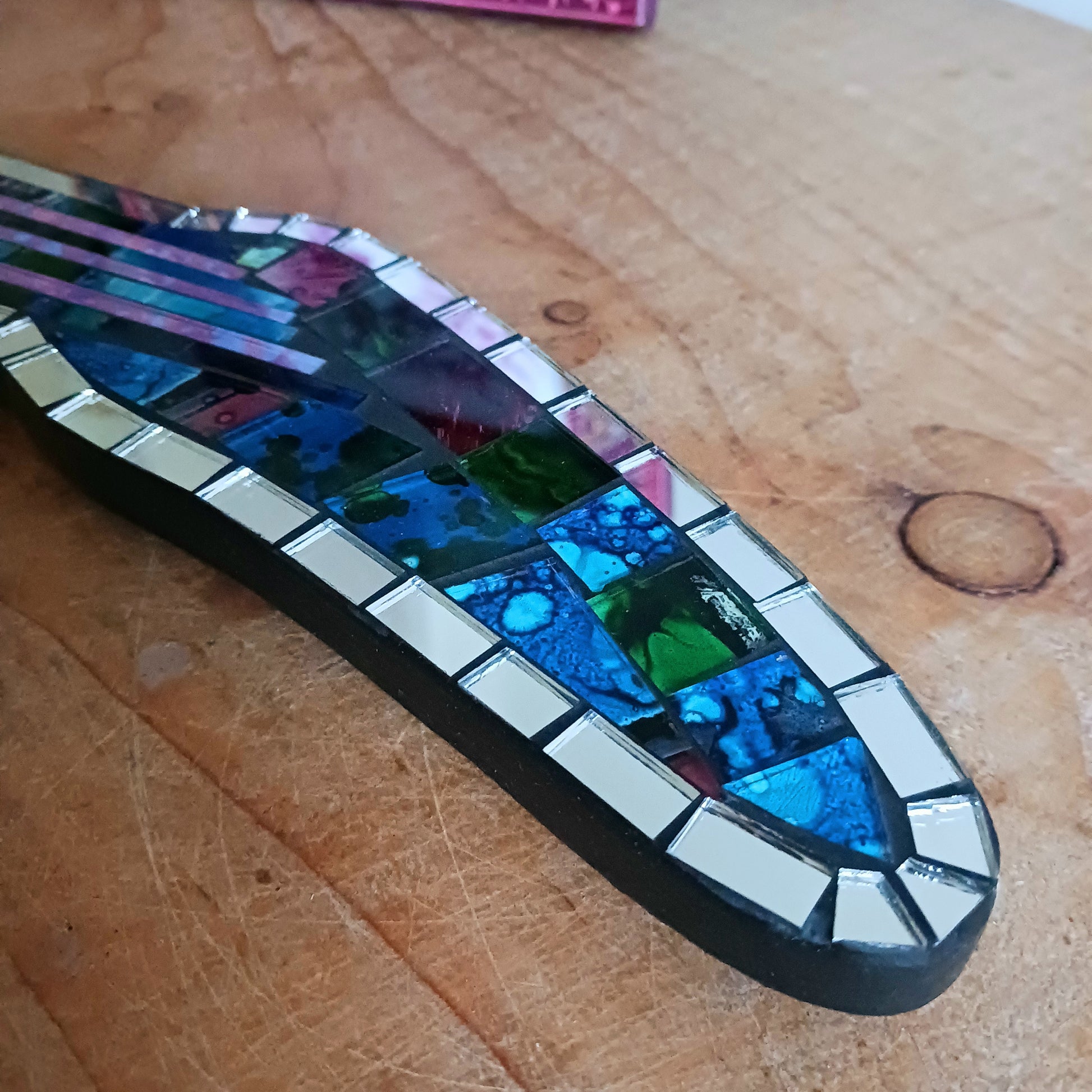 Handcrafted from shimmering, individually placed glass tiles, this stunning guitar-shaped glass mosaic mirror blends creativity, rhythm, and craftsmanship into one striking wall décor accent.