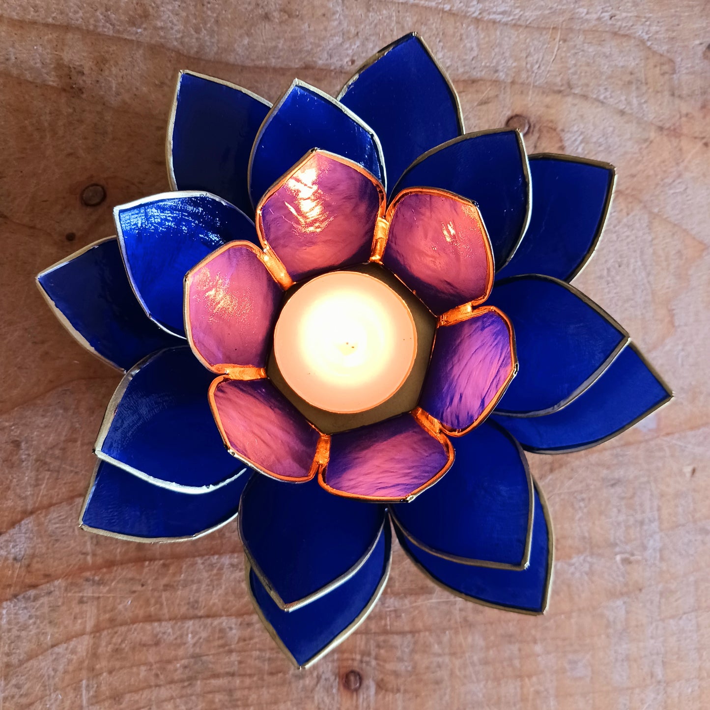 Illuminate your space with the peaceful elegance of our Capiz Shell Lotus Flower Candle Holder. Symbolizing enlightenment and serenity, this stunning handcrafted piece features delicate blue petals edged in gold, forming the iconic lotus shape.