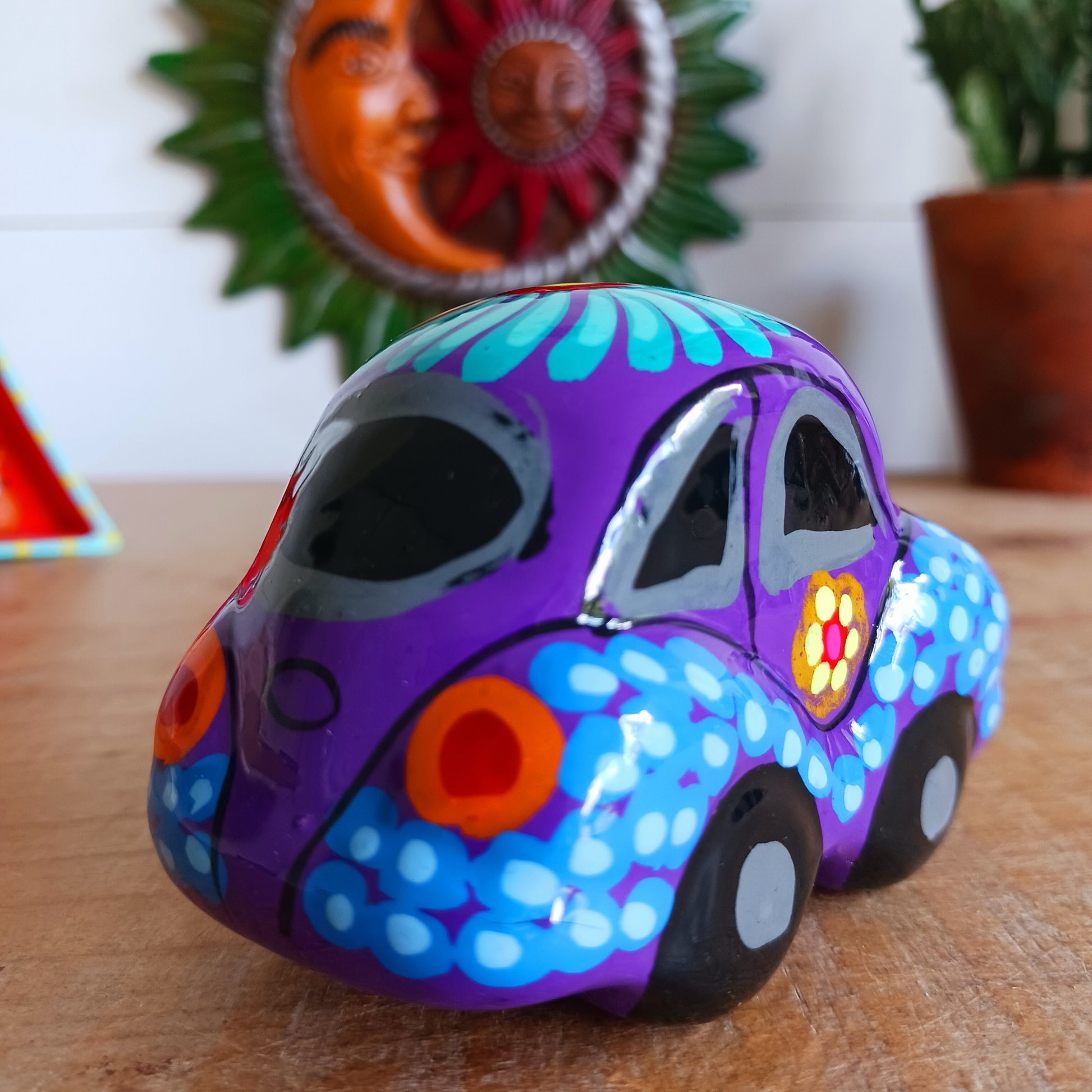 This fun little VW car ornament oozes retro vibes. With it's bold flower power design and vibrant colours it will brighten up any sideboard. This type of car, affectionately known as a 'bochito', are very popular in Mexico due to their reliability when driving about steep roads. Incidentally, the Mexican town of Puebla was home to the last Beetle production factory which only closed in 2003.