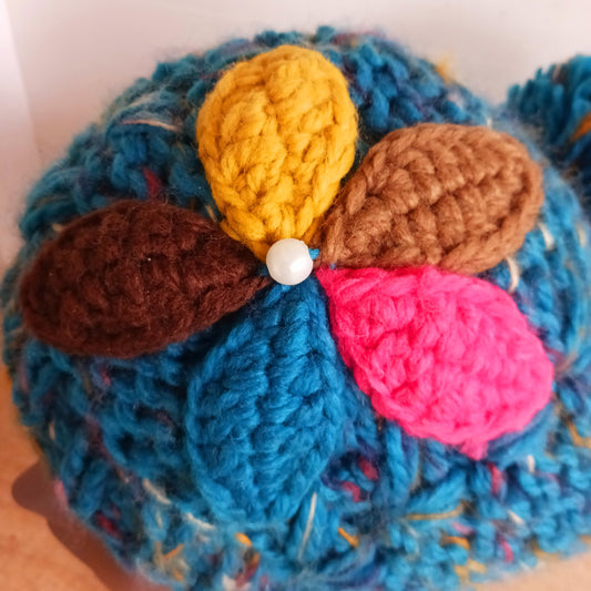 Stay warm in style with this charming knitted wool flower bobble hat, designed to bring both comfort and personality to your winter wardrobe. Crafted from soft, insulating wool, this cozy beanie keeps you snug even on the coldest days.