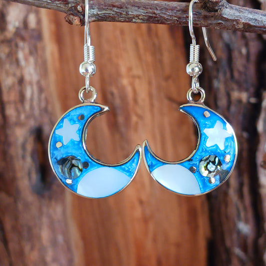 This set of beautiful celestial themed earrings are hand crafted in Taxco, Mexico. Utilising a eye-catching crescent moon design created using traditional Alpaca steel as the frame. These earrings have a celestial theme created using dyed, iridescent abalone shell.