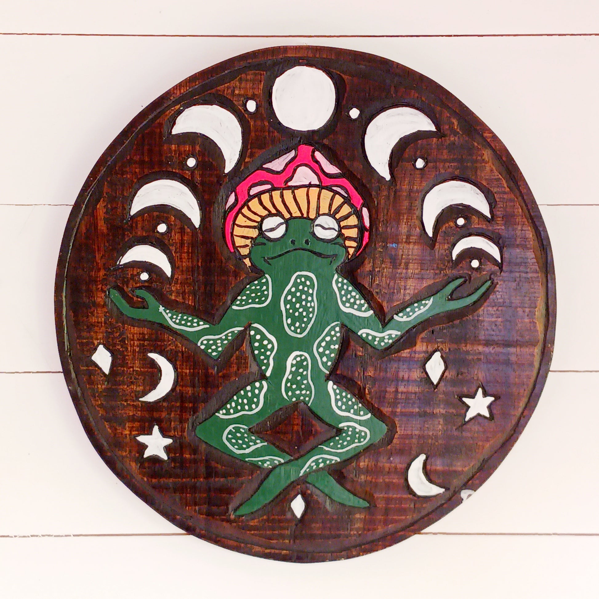 Bring a touch of fun, character, and artisan craftsmanship to your home with this Round Meditating Frog Wall Plaque, beautifully handmade by skilled artisans in Bali, Indonesia. Expertly hand carved from sustainable wood and carefully hand painted, each piece showcases unique details that celebrate traditional Balinese craftsmanship.
