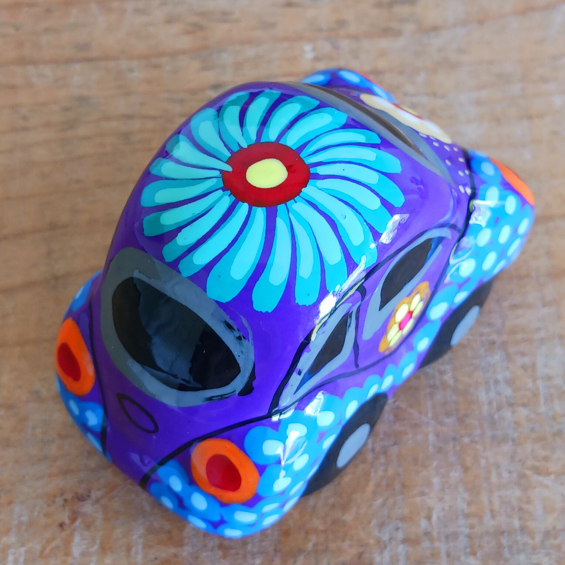 This fun little VW car ornament oozes retro vibes. With it's bold flower power design and vibrant colours it will brighten up any sideboard. This type of car, affectionately known as a 'bochito', are very popular in Mexico due to their reliability when driving about steep roads. Incidentally, the Mexican town of Puebla was home to the last Beetle production factory which only closed in 2003.